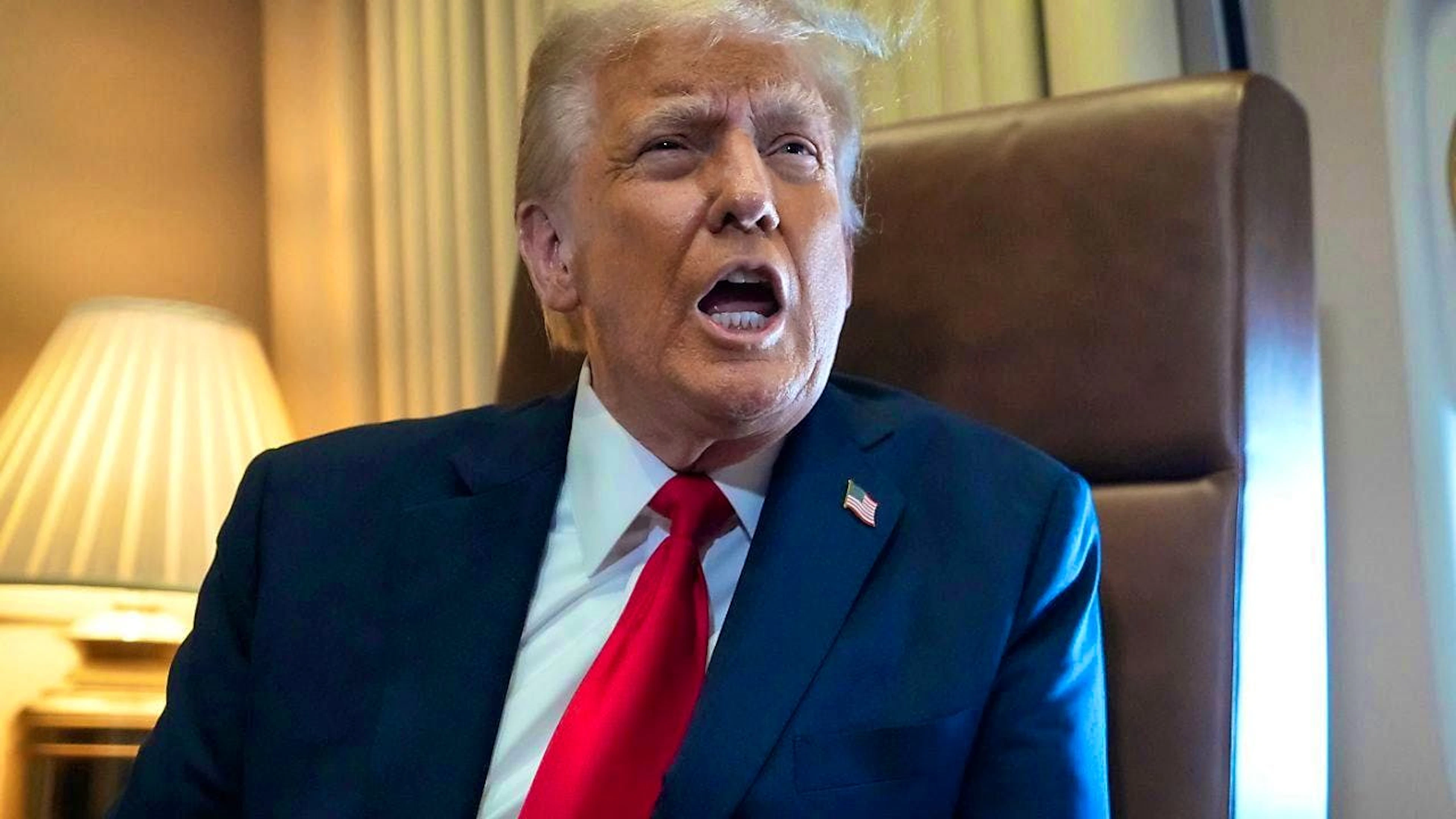 US President Donald Trump speaks to reporters on board Air Force One. Photo: Ben Curtis/AP/dpa