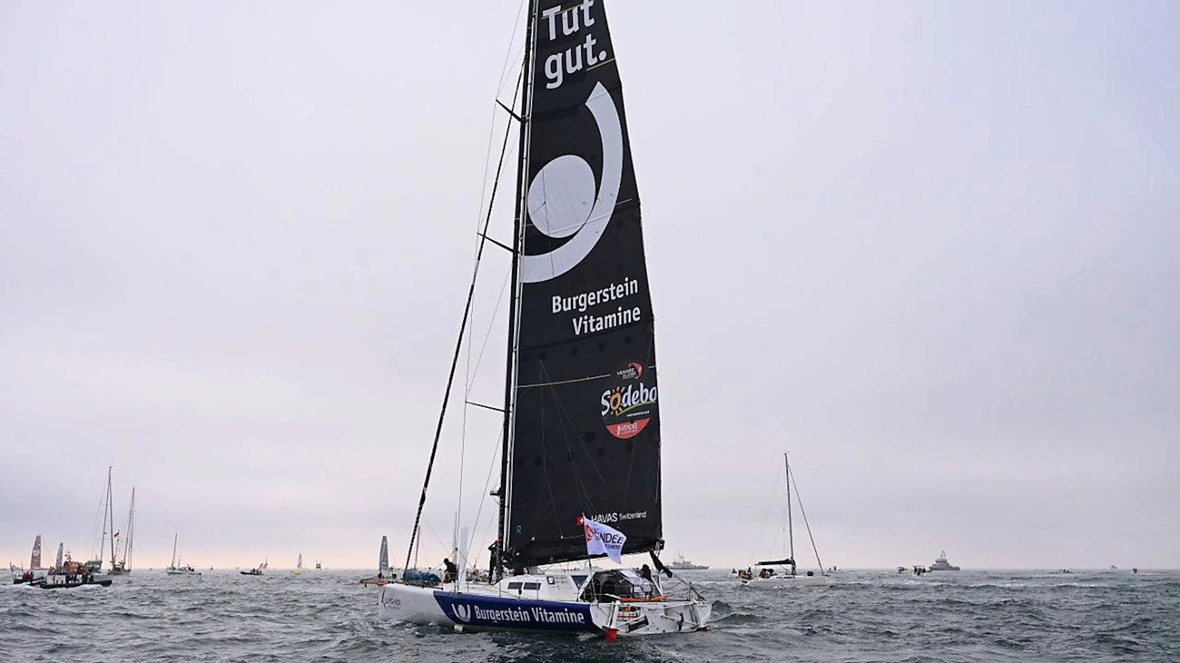 Oliver Heer et son bateau lors de son départ du Vendée Globe en novembre (archives).