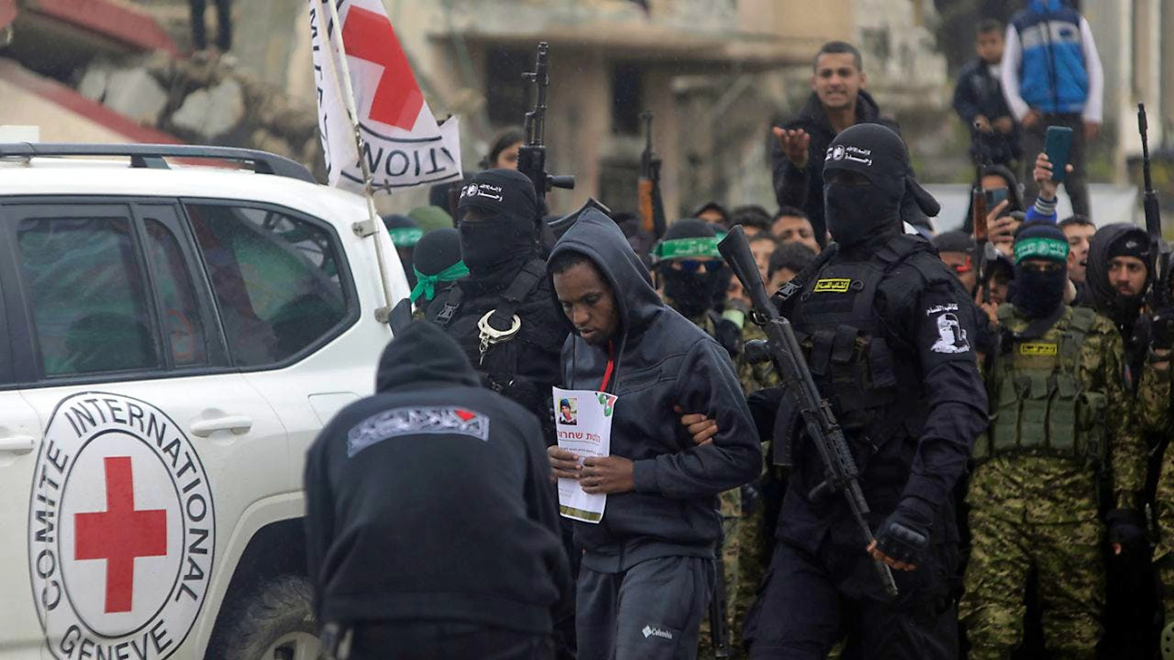 dpatopbilder - Die israelische Geisel Avera Mengistu wird von vermummten und bewaffneten Mitgliedern der Terrororganisation Hamas in Rafah im südlichen Gazastreifen dem Internationalen Roten Kreuz übergeben. Foto: Jehad Alshrafi/AP/dpa