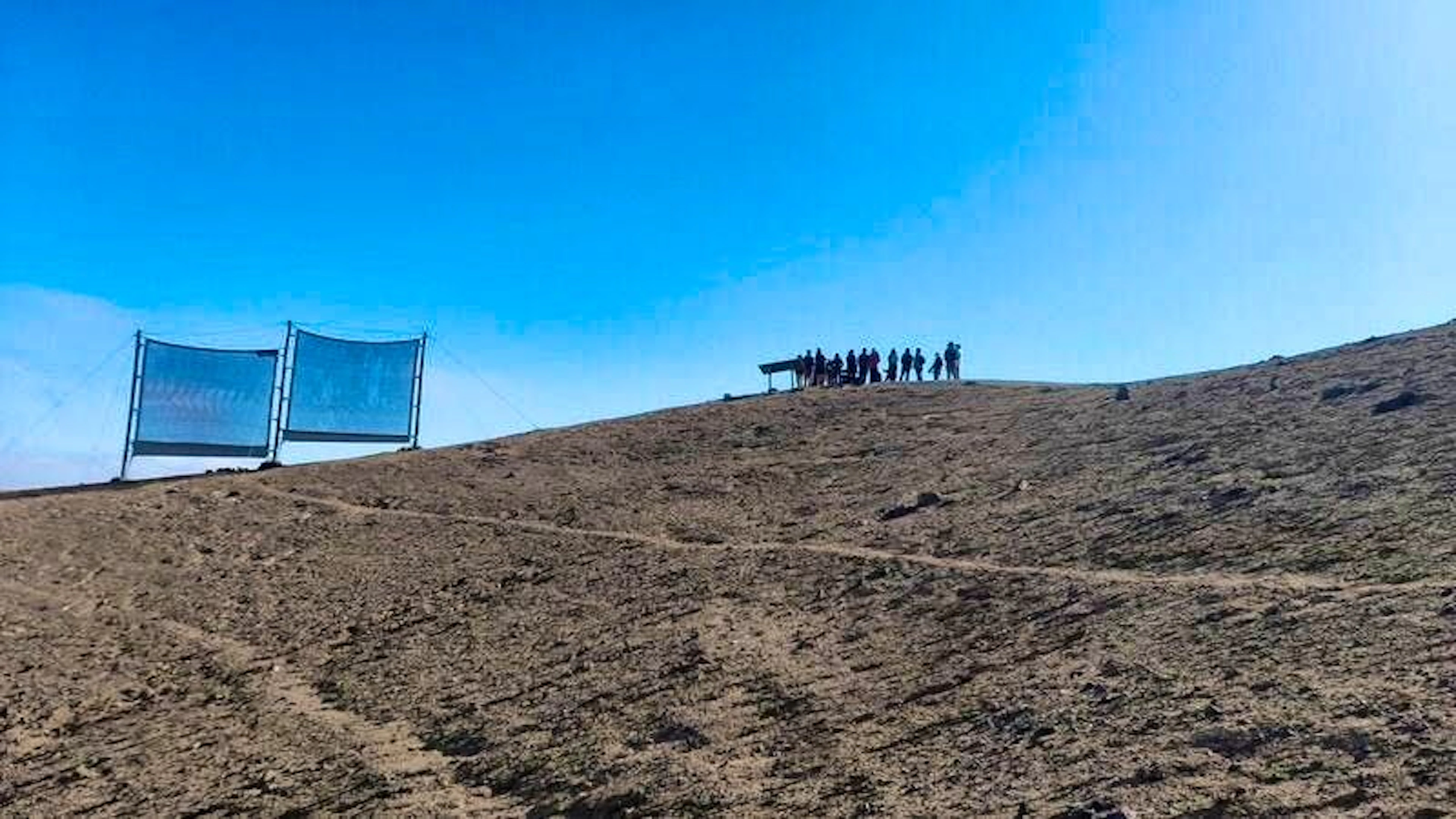 Studenti in piedi accanto ai collettori secondari fuori dalla città di Alto Hospicio.