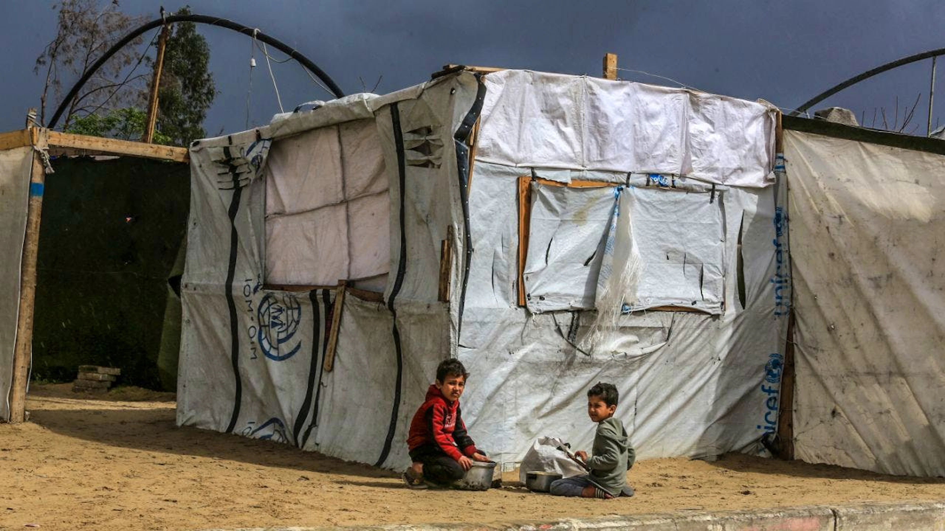 ARCHIV - Kinder tragen Töpfe mit Lebensmitteln vor Zelten von vertriebenen Palästinensern in Al Mawasi. Foto: Abed Rahim Khatib/dpa