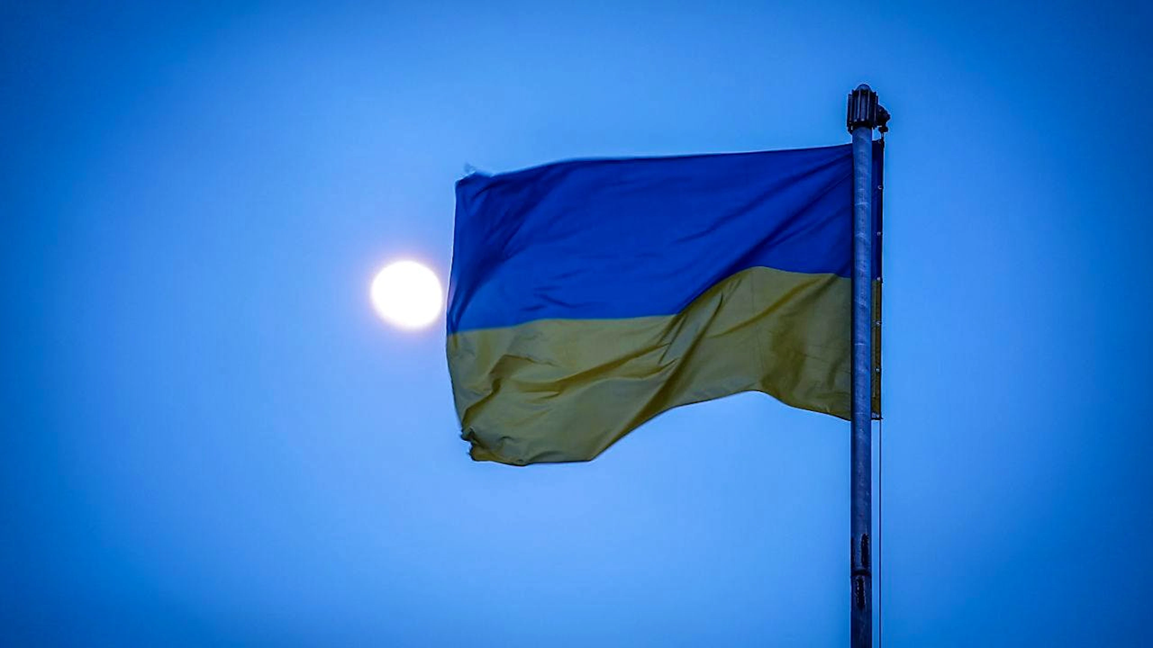 ARCHIV - Die Flagge der Ukraine weht über der Hafenstadt im Mondlicht im Wind. Foto: Kay Nietfeld/dpa