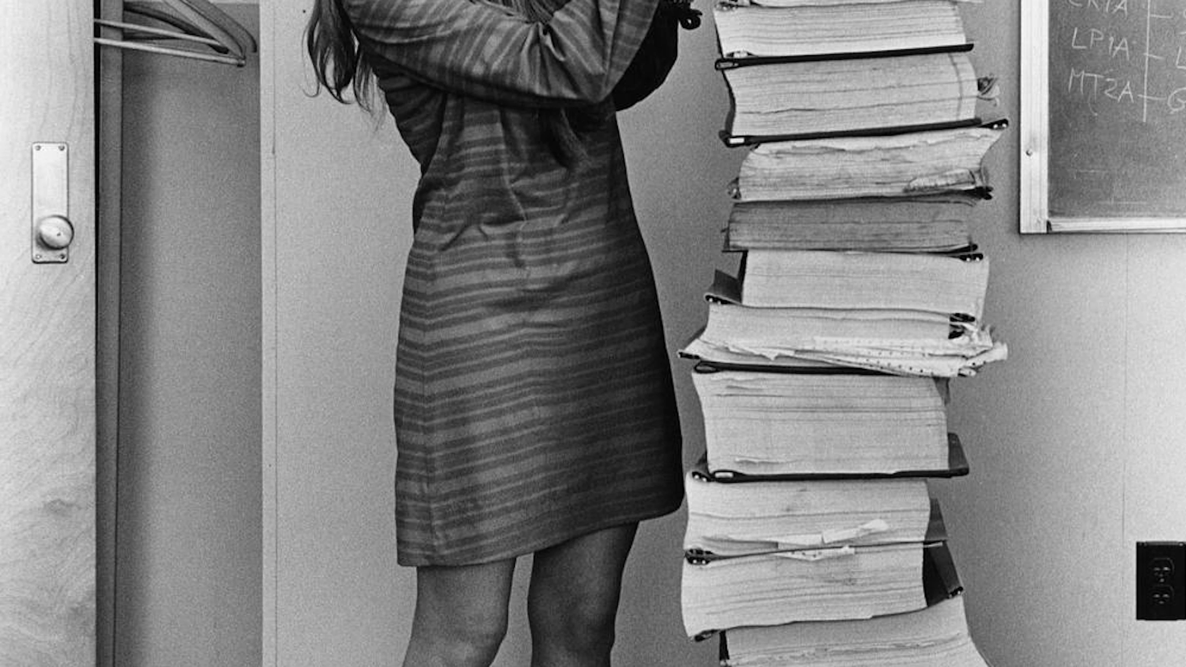 Margaret Hamilton neben Ausdrucken der Apollo-Flugsoftware.