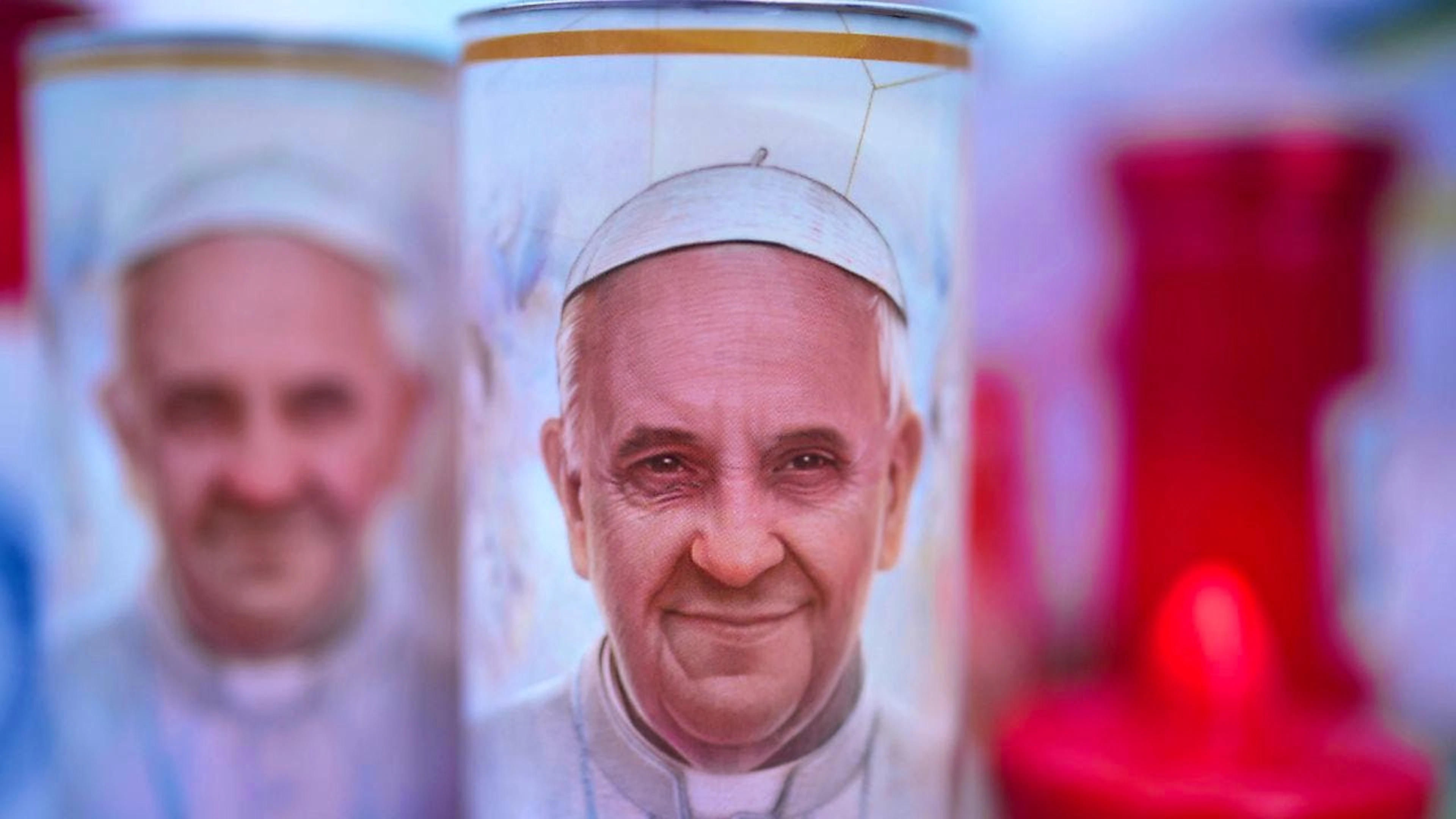 Kerzen mit Fotos von Papst Franziskus.