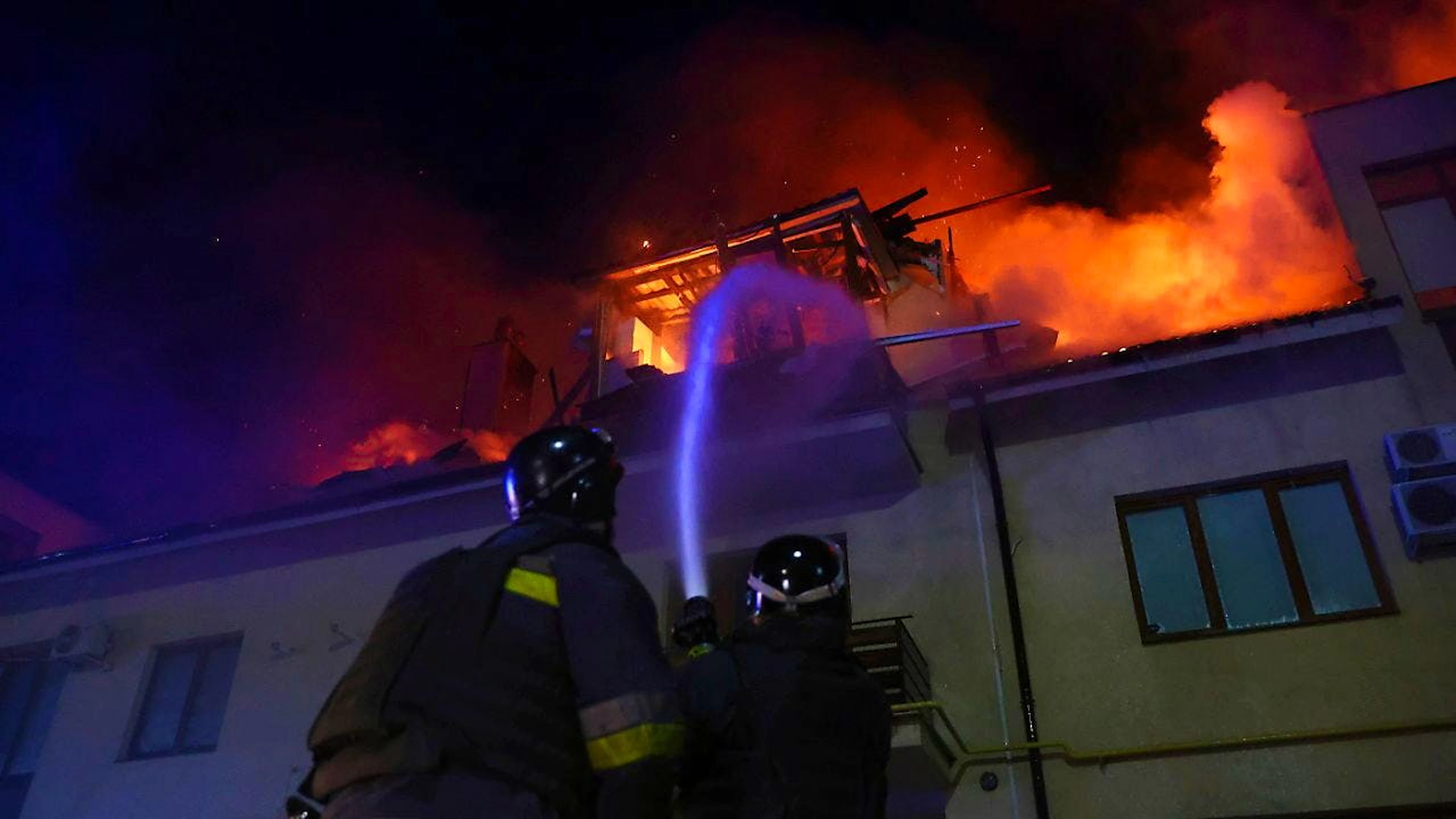 dpatopbilder - Rettungskräfte löschen ein Feuer in einem brennenden Haus, das bei einem russischen Drohnenangriff auf ein Wohnviertel in Saporischschja (Ukraine) getroffen wurde. Foto: Kateryna Klochko/AP/dpa