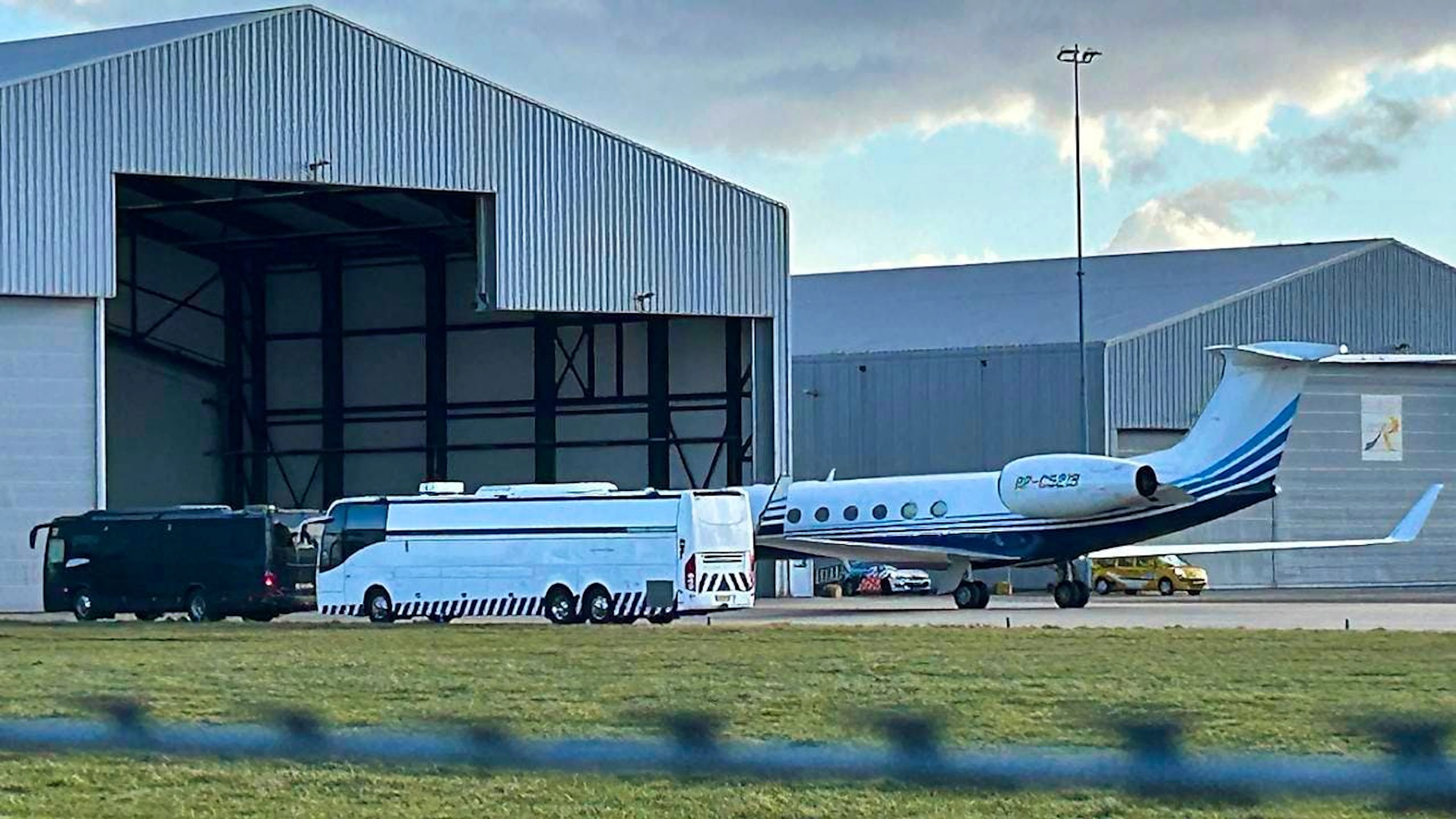 Ein Flugzeug, das vermutlich den ehemaligen philippinischen Präsidenten Duterte transportiert hat, steht neben einem Bus am Flughafen Rotterdam Den Haag. Foto: Mark Carlson/AP/dpa