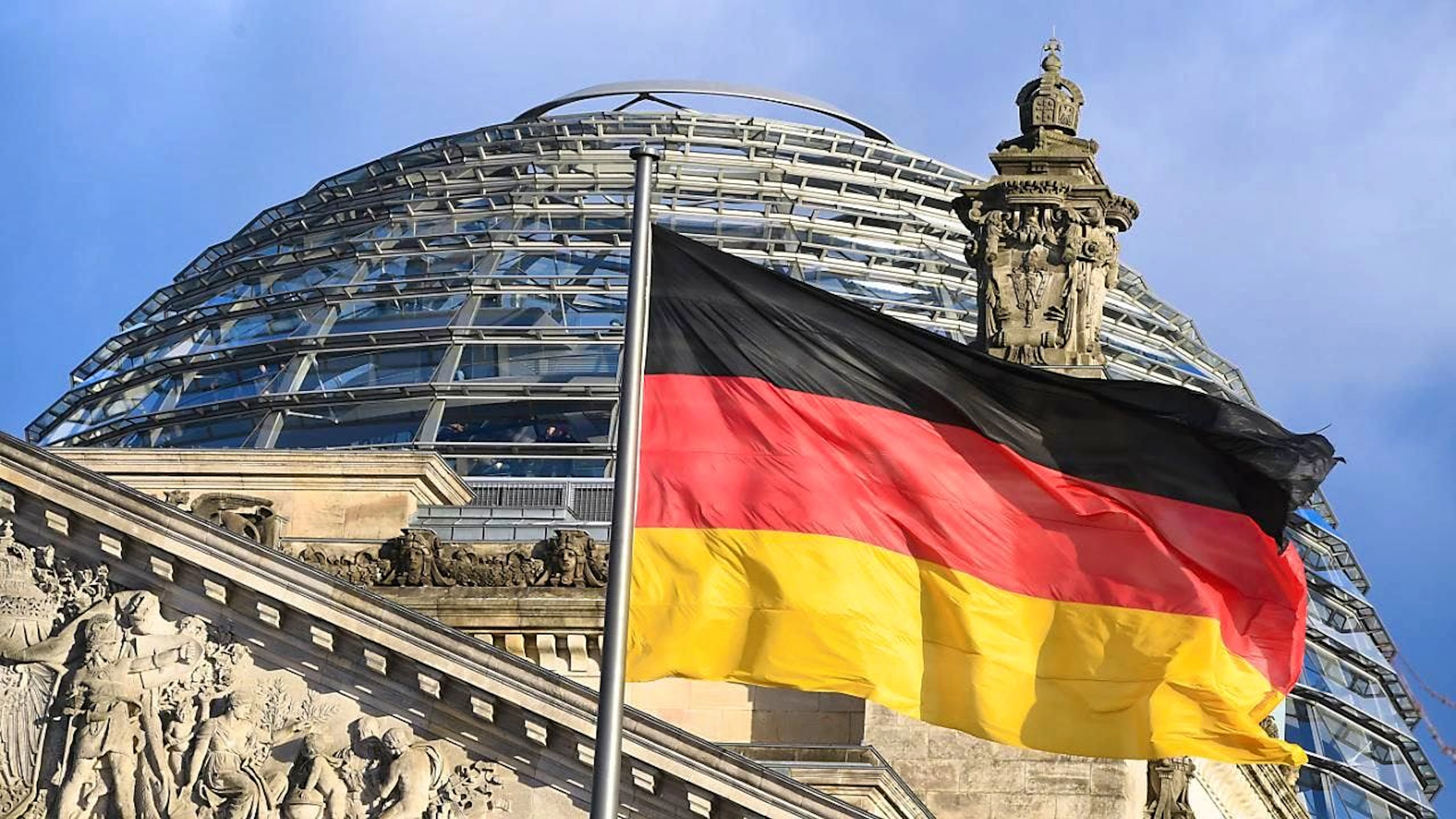ARCHIV - Die schwarz-rot-goldene Flagge weht  vor der Kuppel des Reichstages. Foto: Soeren Stache/dpa