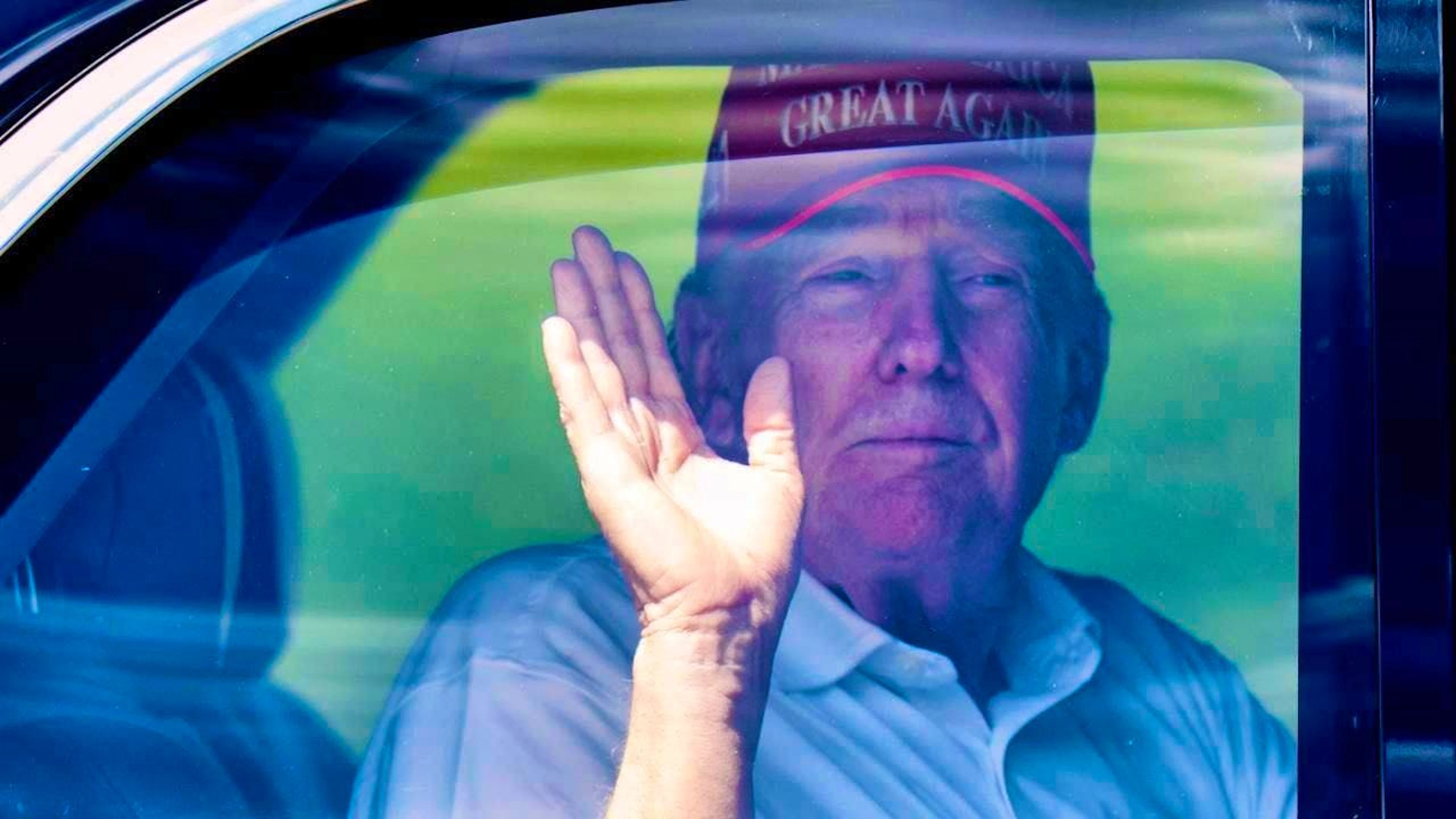 US President Donald Trump waves from his limousine as he leaves the Trump International Golf Club. Photo: Manuel Balce Ceneta/AP/dpa