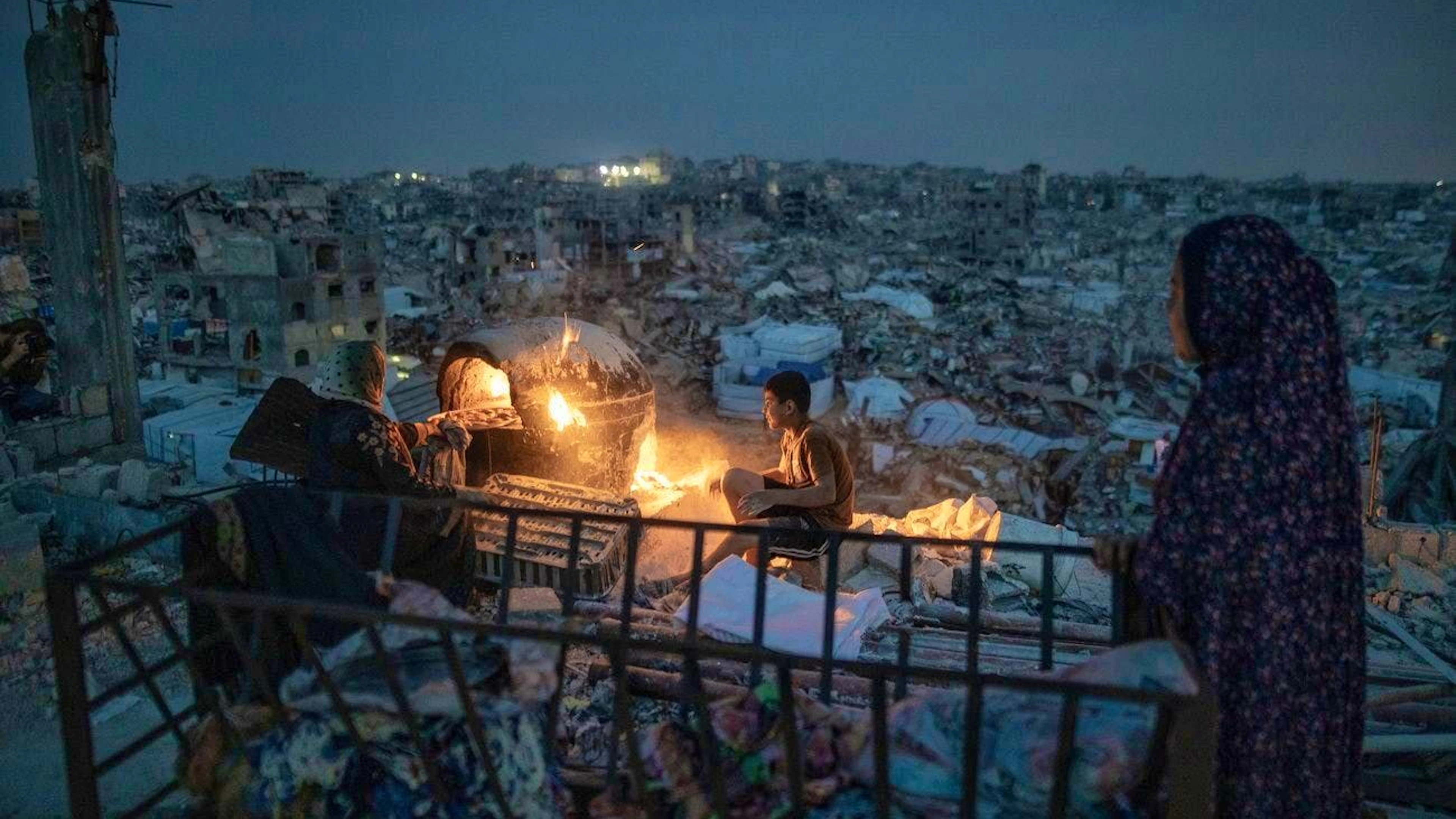 A Palestinian family prepares their dinner in the rubble in Jabalia on March 17.