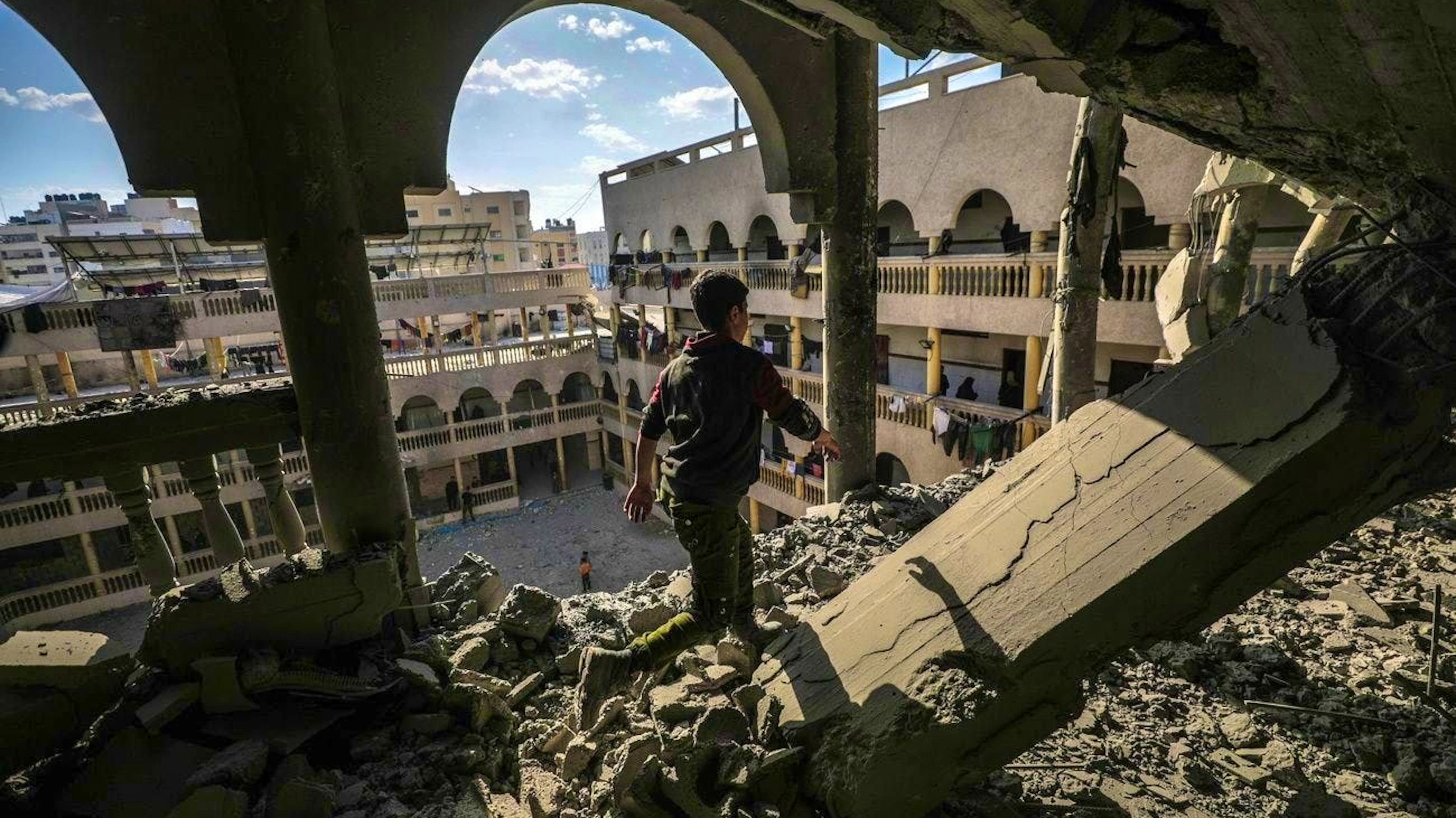 A Palestinian boy inspects the damage to a school in Gaza City this morning after an Israeli airstrike.