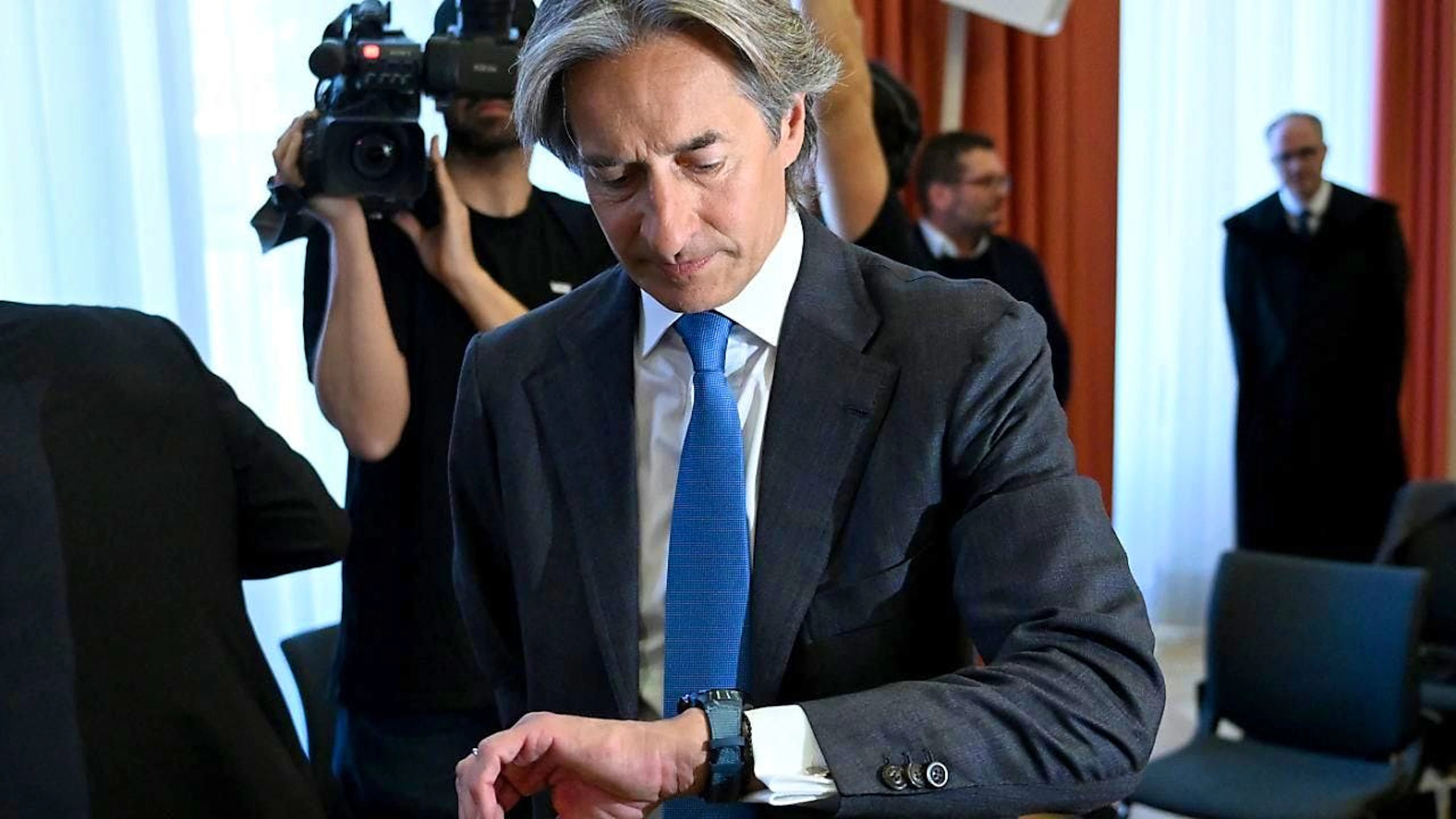 Karl Heinz Grasser, ehemaliger Finanzminister  von Österreich, schaut vor Verhandlungsbeginn auf die Uhr. Grasser wurde wegen Bestechlichkeit in erster Instanz verurteilt. Nun prüft der Oberste Gerichtshof. Foto: Roland Schlager/APA/dpa