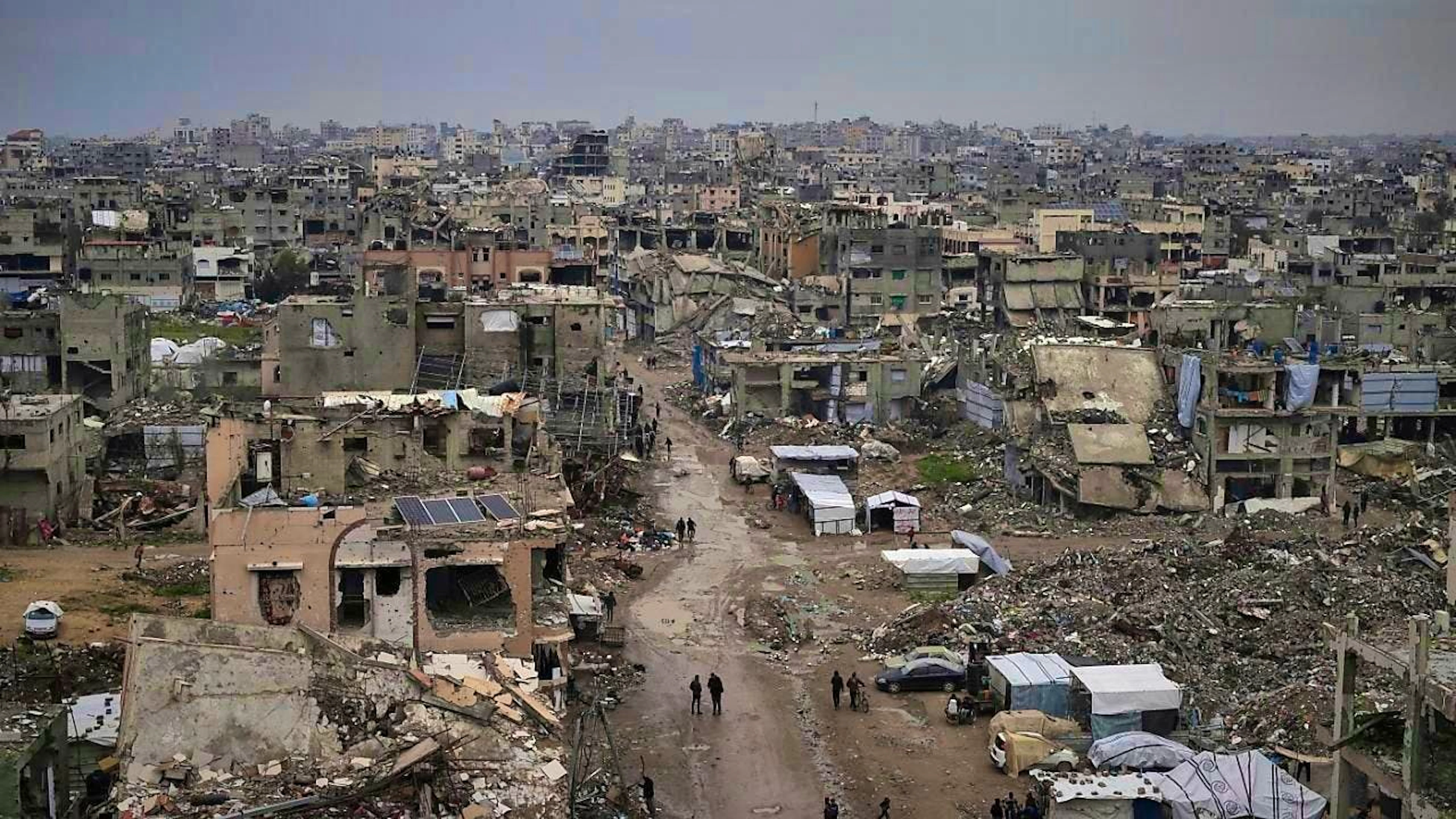 ARCHIVE - Palestinians walk through the rubble of destroyed houses and buildings in Gaza City. Photo: Jehad Alshrafi/AP/dpa