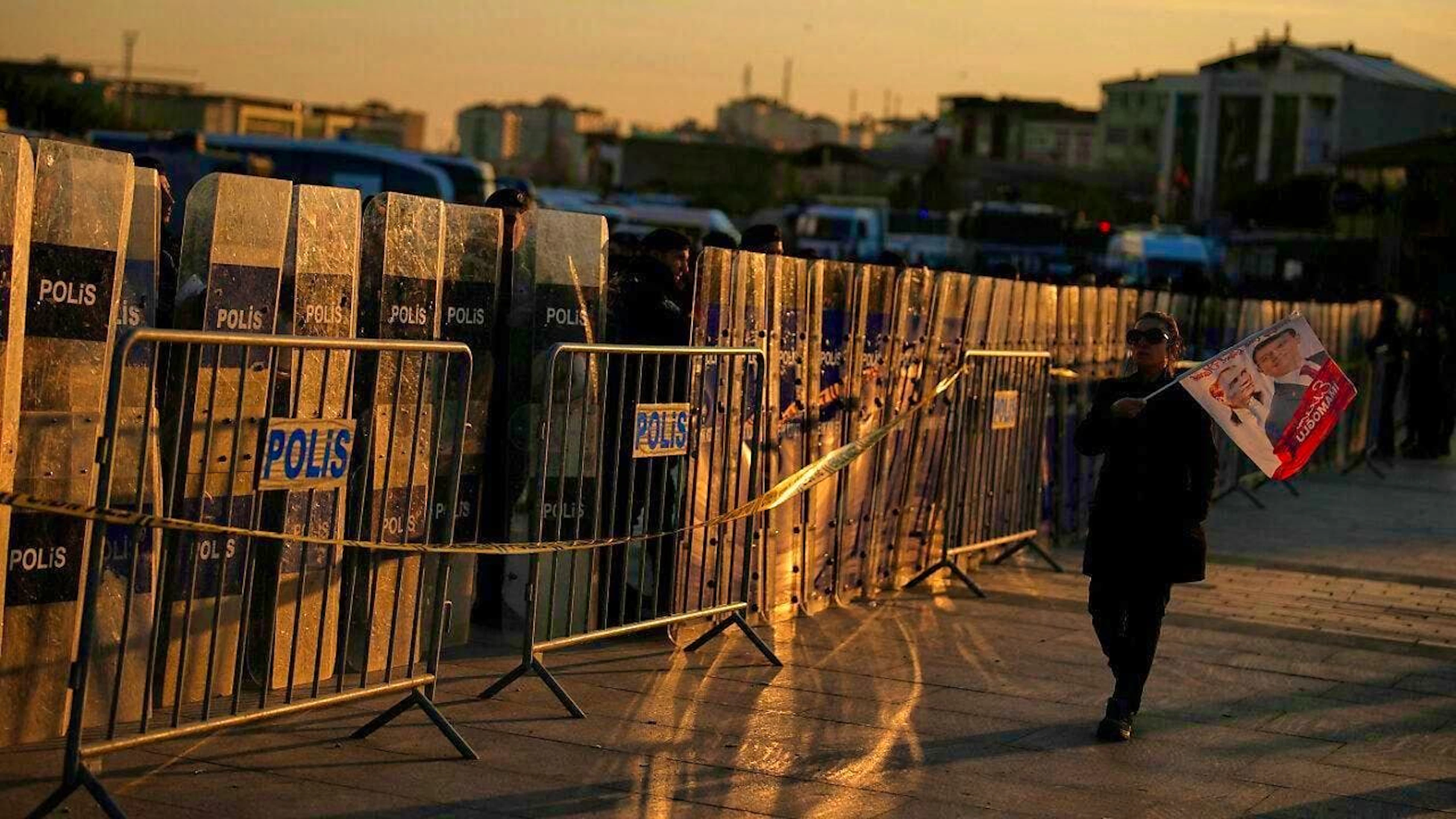 A woman walks past riot police officers in Istanbul Photo: Emrah Gurel/AP/dpa
