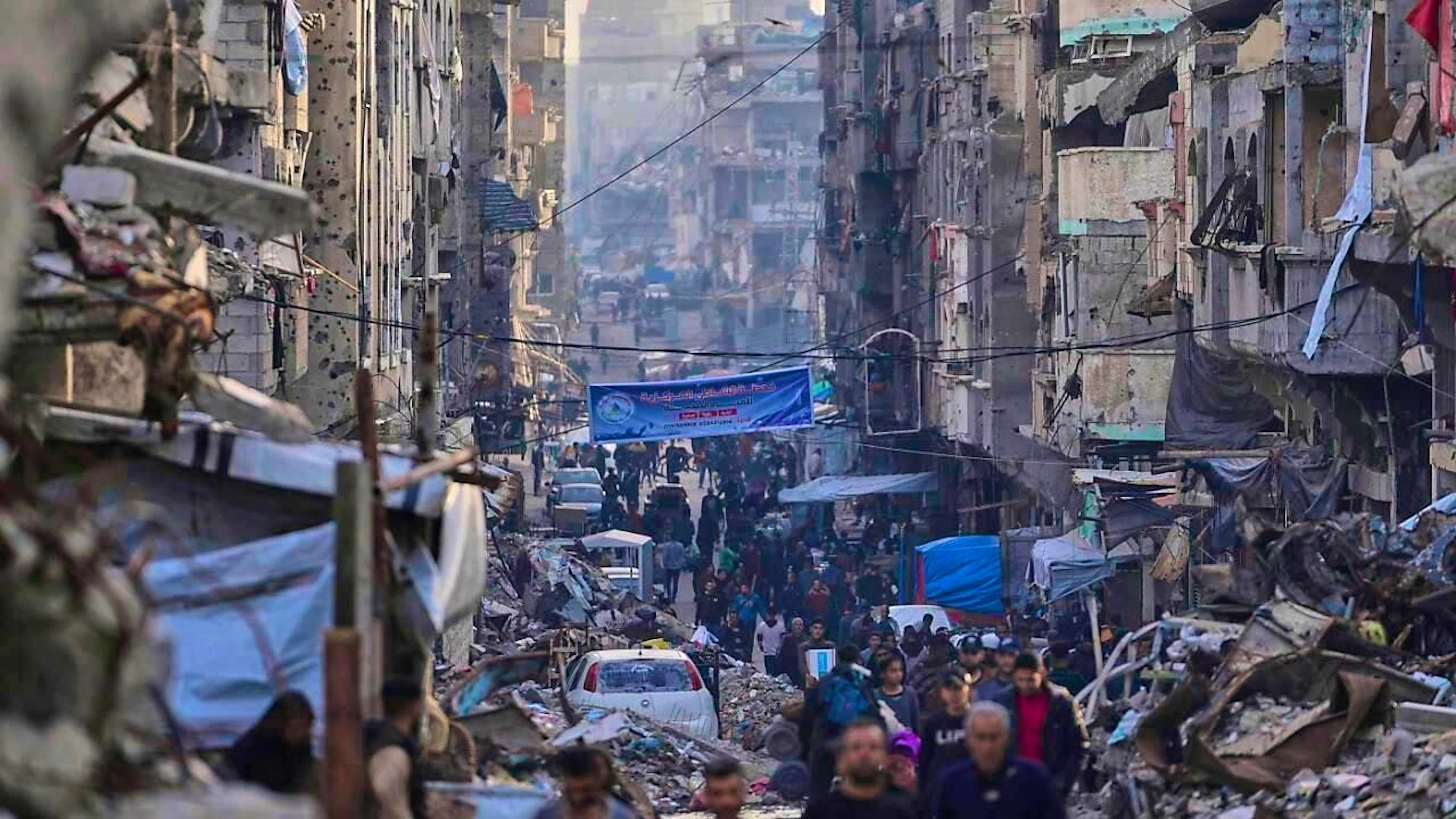 Palestinians walk through a destroyed street after an Israeli air and ground offensive in Gaza City. Photo: Jehad Alshrafi/AP/dpa