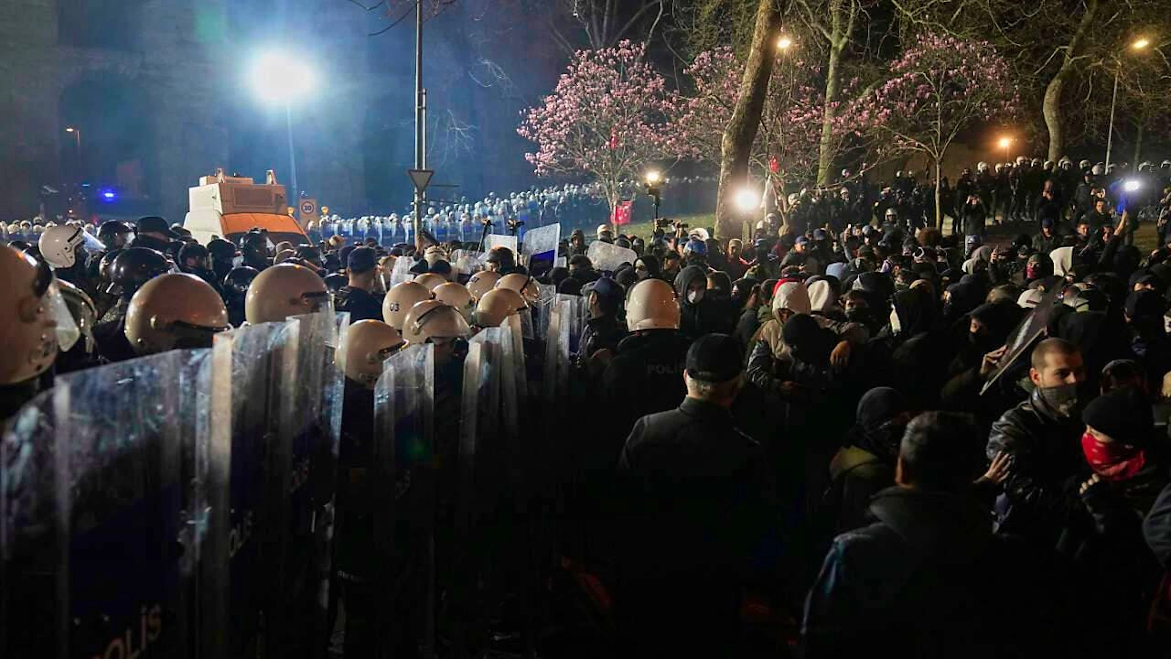 Demonstranten stehen neben der Polizei während einer Demonstration gegen die Festnahme des Istanbuler Bürgermeisters Imamoglu. Foto: Khalil Hamra/AP/dpa