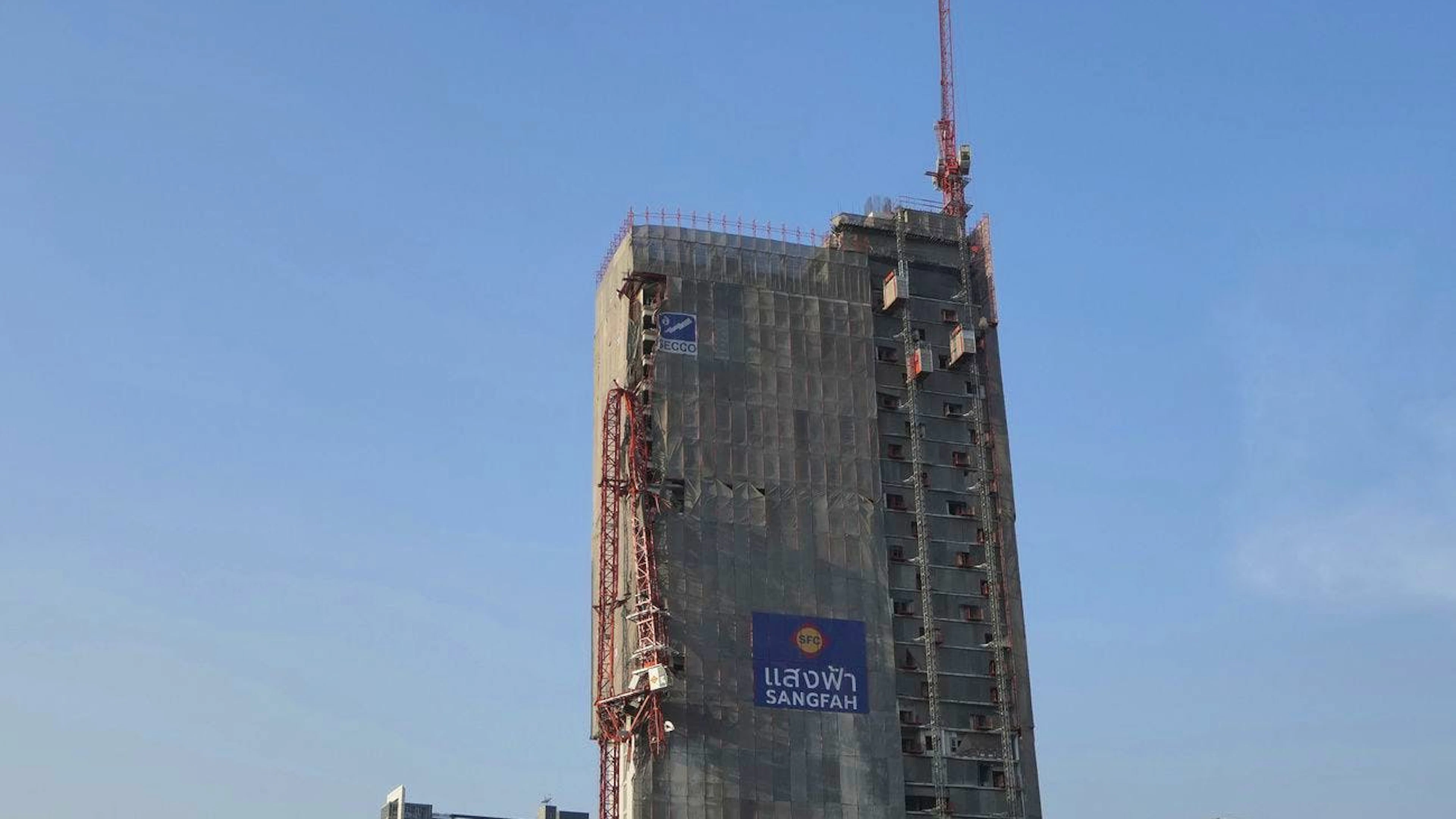 Una gru danneggiata sulla facciata di un edificio in costruzione a Bangkok.