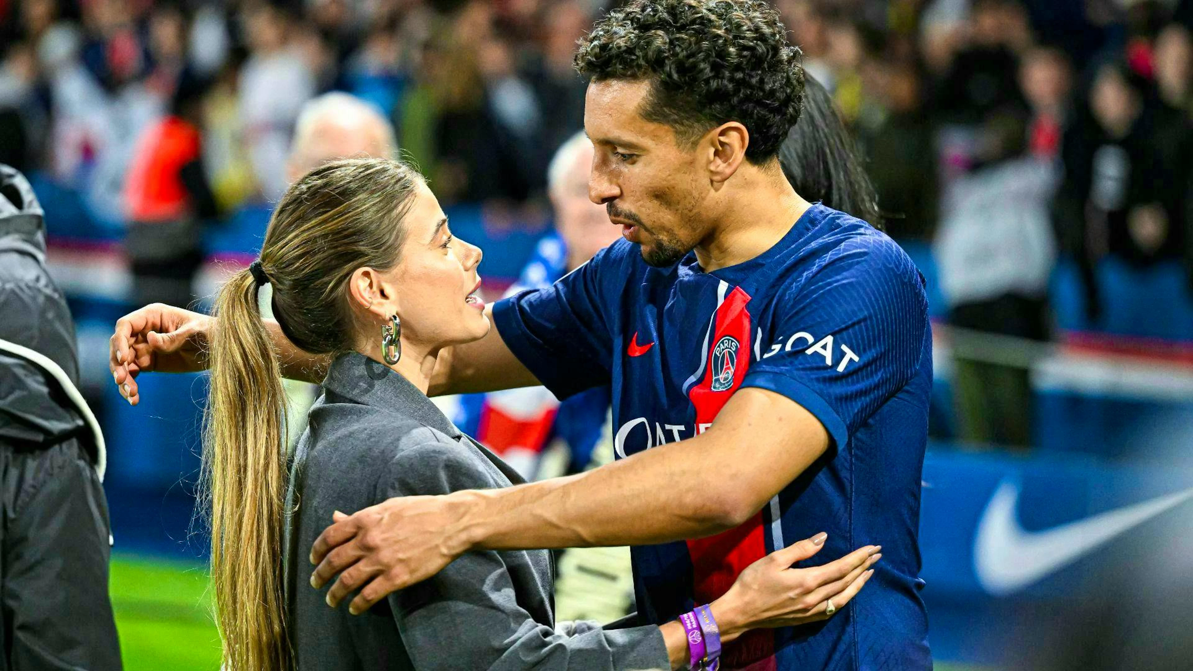 Marquinhos is embraced by his wife Carol Cabrino after a game.