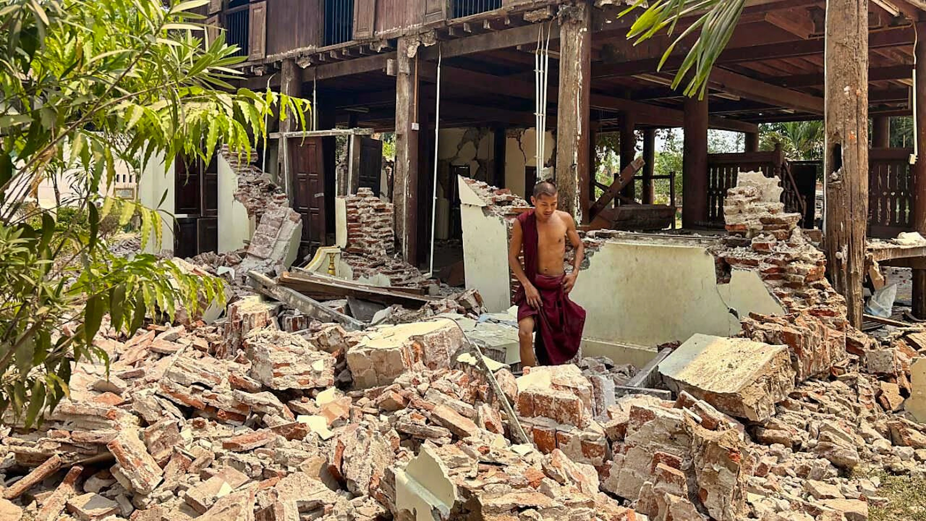 Ein buddhistischer Mönch steht in den Trümmern eines beschädigten Gebäudes in einer Klosteranlage nach einem Erdbeben. Foto: Aung Shine Oo/AP/dpa