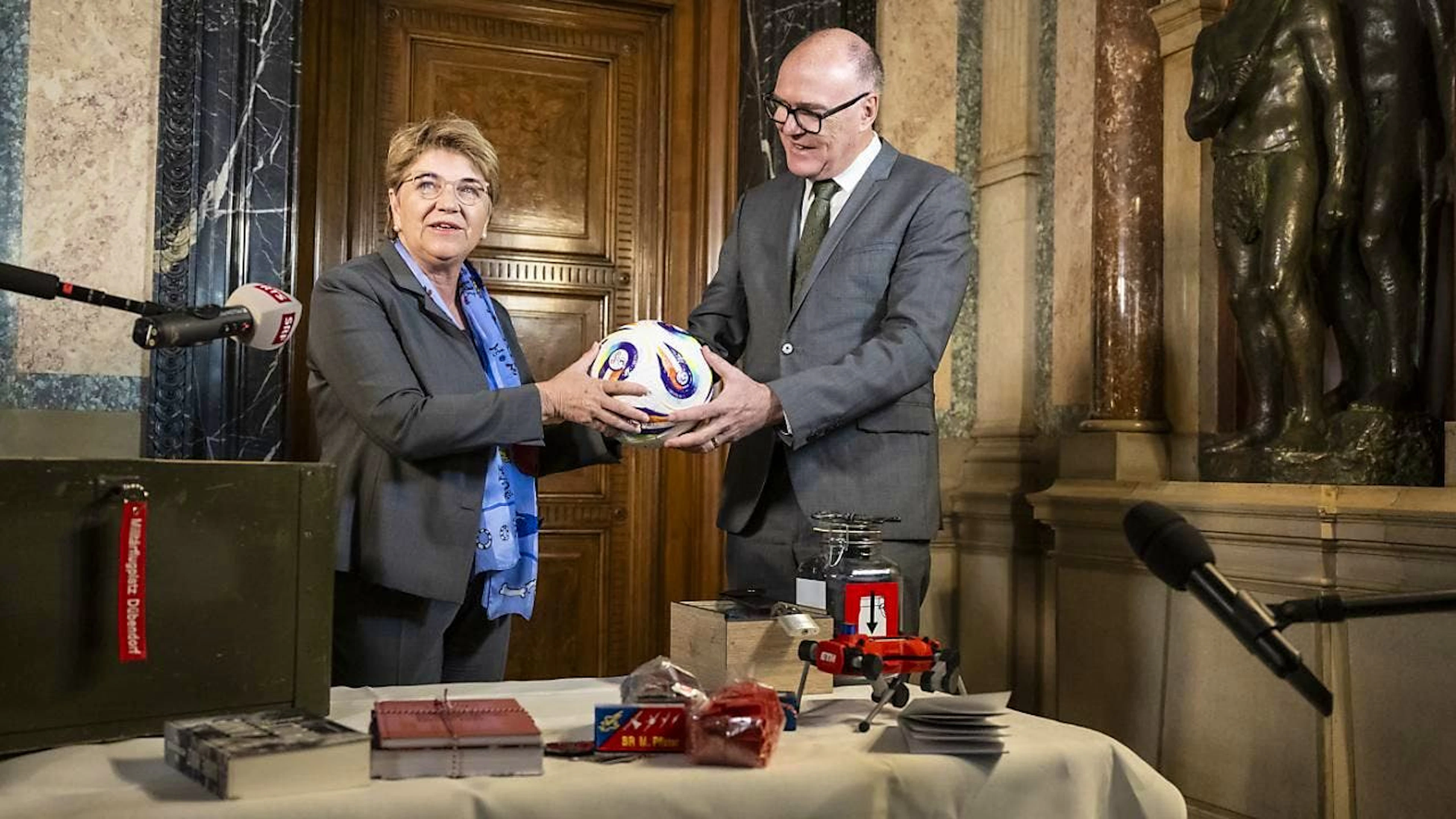 Neben ihrem Büroschlüssel übergab die abtretende Bundesrätin Viola Amherd ihrem Nachfolger Martin Pfister zahlreiche Geschenke, beispielsweise den offiziellen Spielball der Frauen-Fussball-Europameisterschaft.