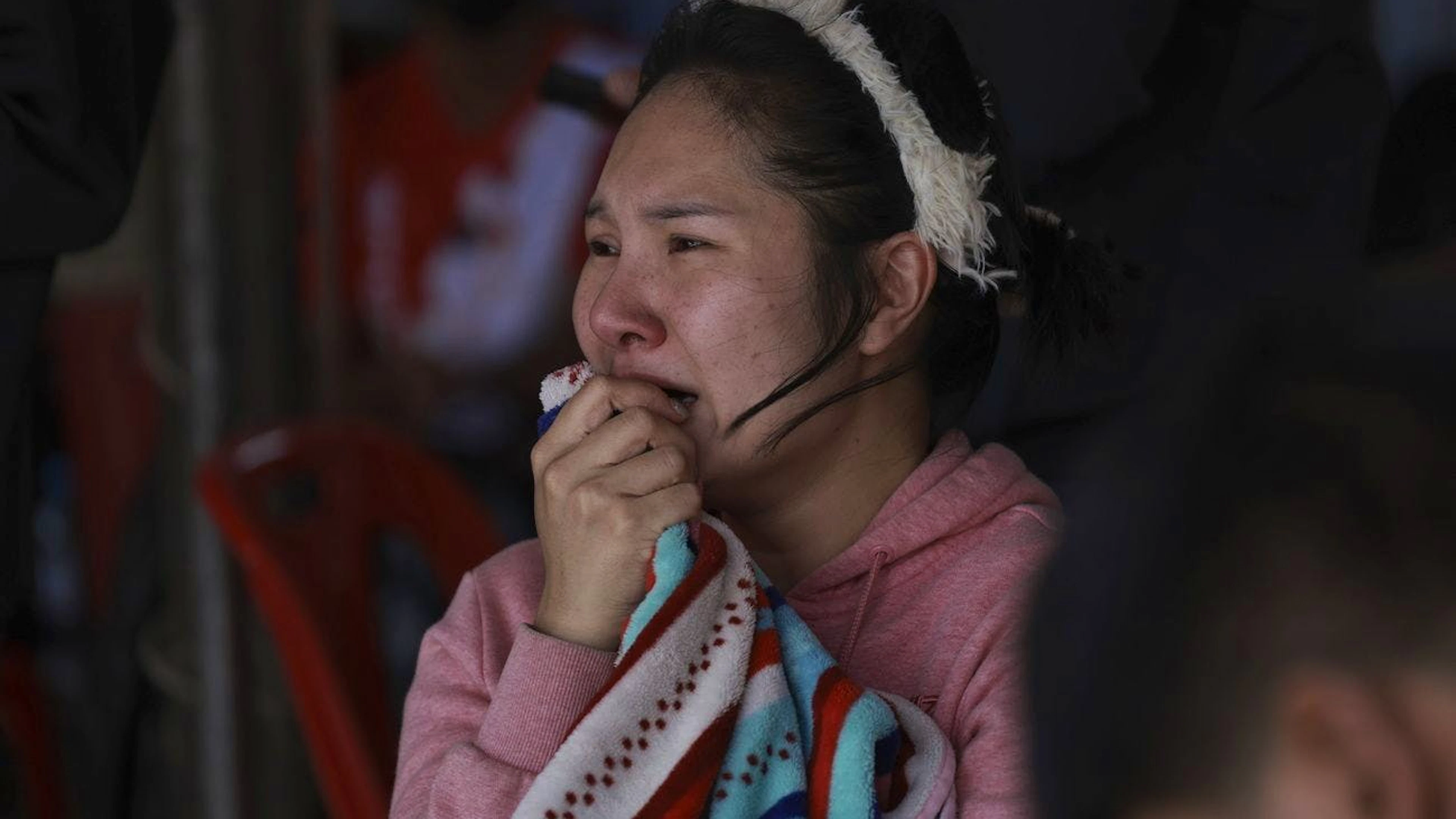 Una donna reagisce mentre osserva i soccorritori sul sito del grattacielo in costruzione crollato a Bangkok.