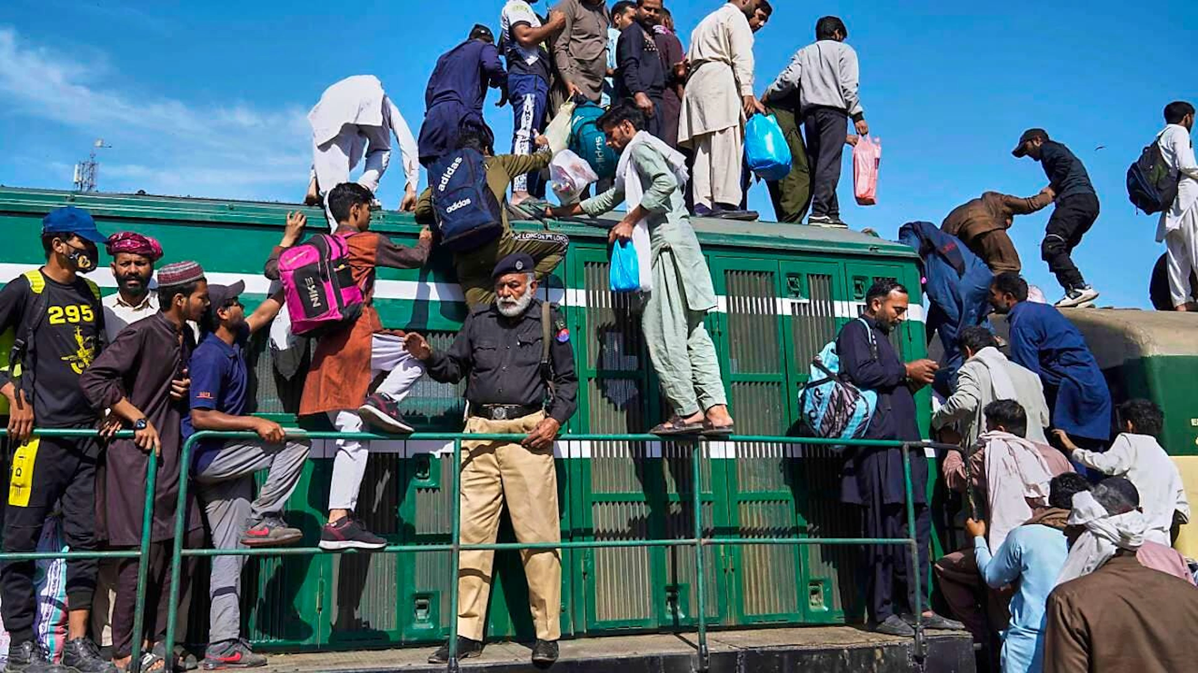 Menschen besteigen an einem Bahnhof in Lahore einen überfüllten Personenzug, um ihre Häuser zu erreichen und das bevorstehende Eid al-Fitr-Fest zu feiern, das das Ende des heiligen islamischen Fastenmonats Ramadan markiert. Foto: K.M. Chaudary/AP/dpa