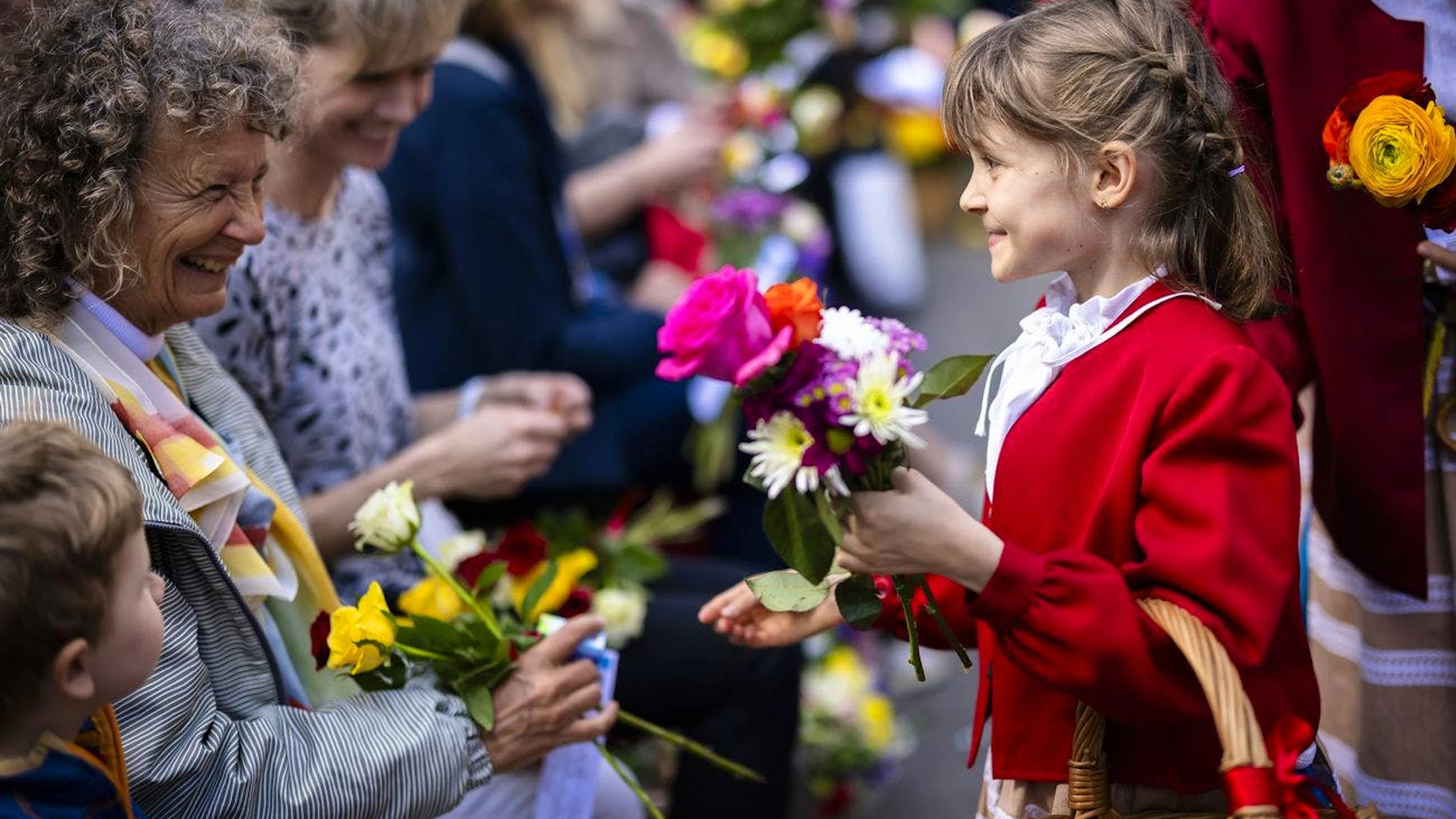 Ein Mädchen verteilt Blumen an Zuschauer am traditionellen Umzug der Zünfte.