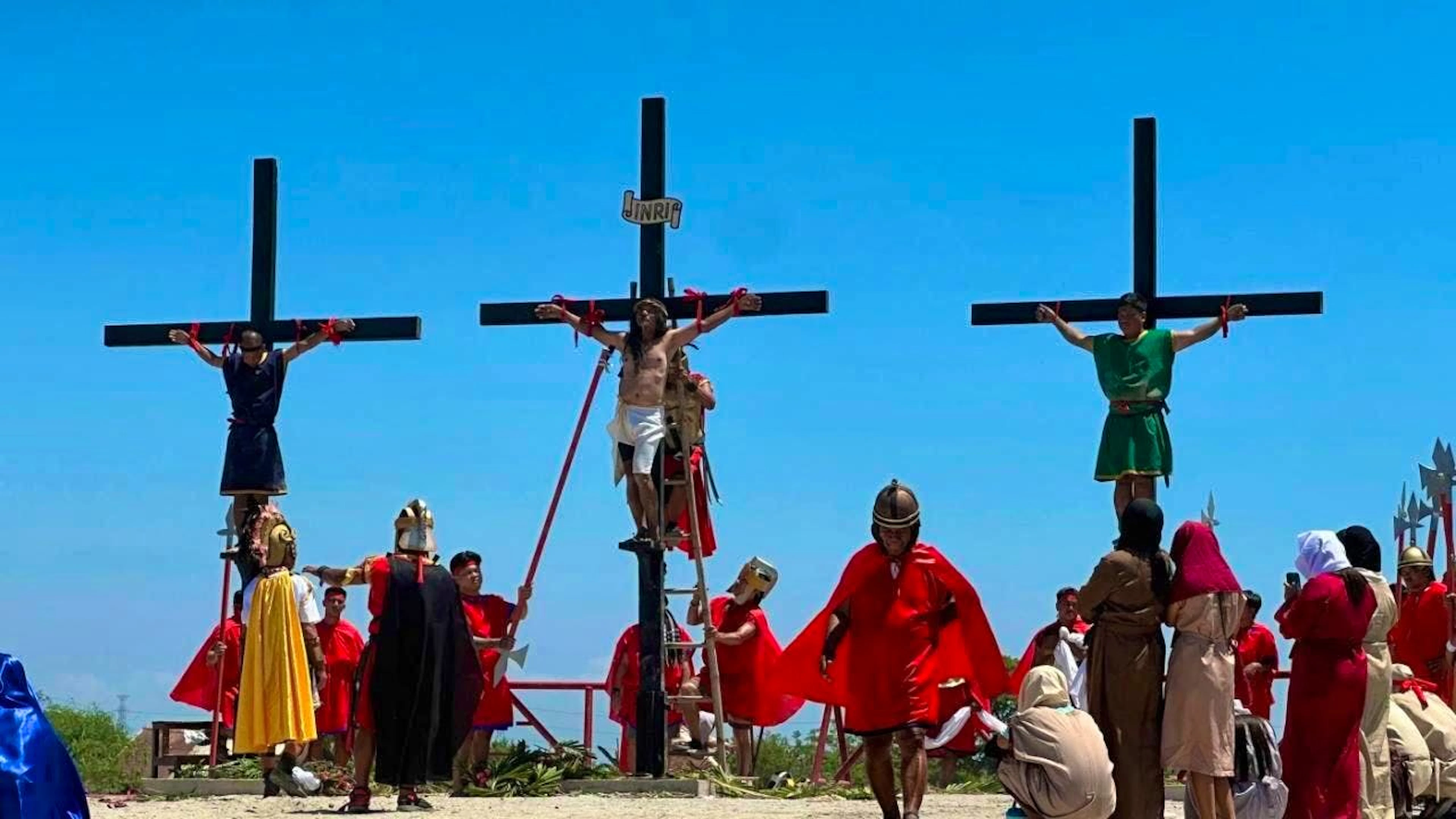 Three Filipino believers hang from three wooden crosses during the depiction of the crucifixion of Jesus Christ. Photo: Joeal Calupitan/AP/dpa