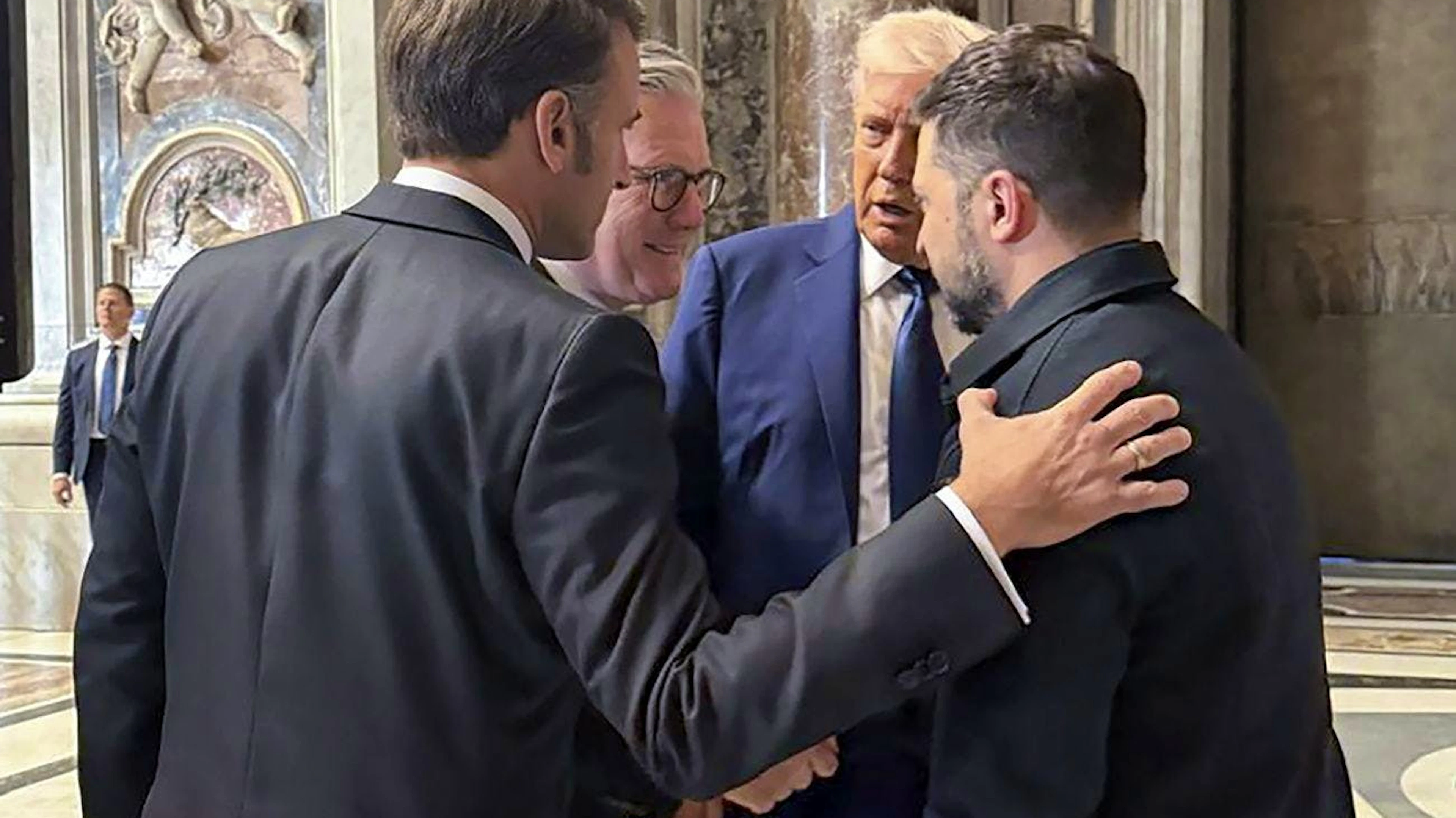 Une photo fournie par le service de presse présidentiel ukrainien montre (de gauche à droite) le président français Emmanuel Macron, le Premier ministre britannique Keir Starmer, le président américain Donald J. Trump et le président ukrainien Volodymyr Zelensky s'exprimant dans la basilique Saint-Pierre avant la messe funéraire du pape François sur la place Saint-Pierre au Vatican, le 26 avril 2025
