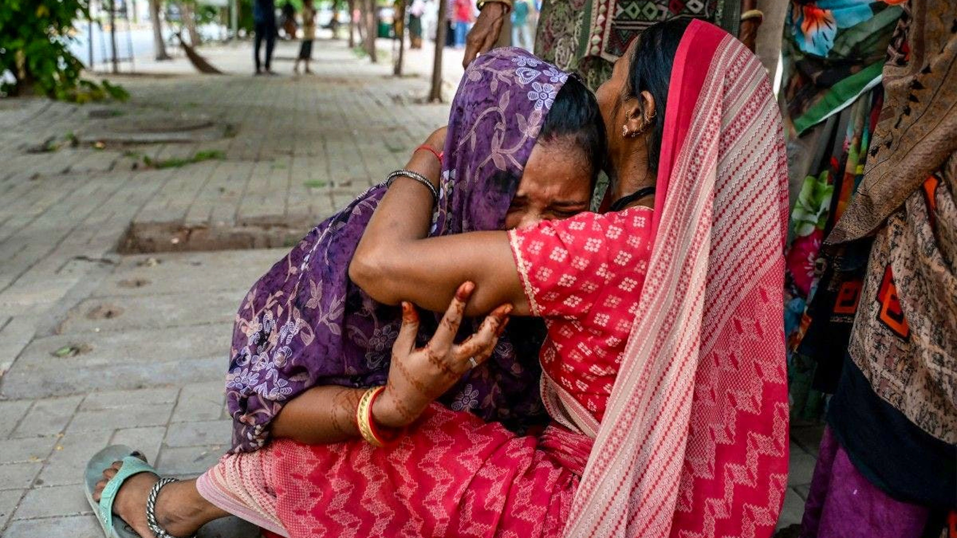 Deux femmes pleurent leurs proches tués, en attendant devant la morgue de l'hôpital à Ahmedabad.