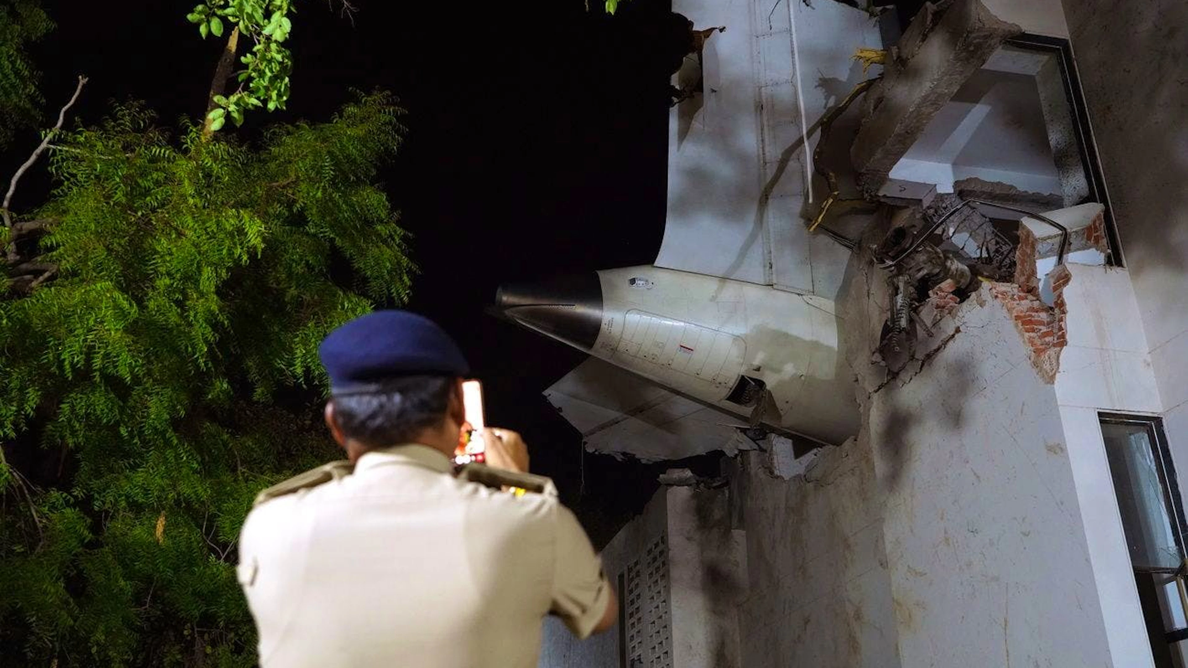 Un officier se tient sur le site d'un accident d'avion près de l'aéroport international Sardar Vallabhbhai Patel à Ahmedabad, dans l'État du Gujarat, dans l'ouest de l'Inde, le 12 juin 2025.