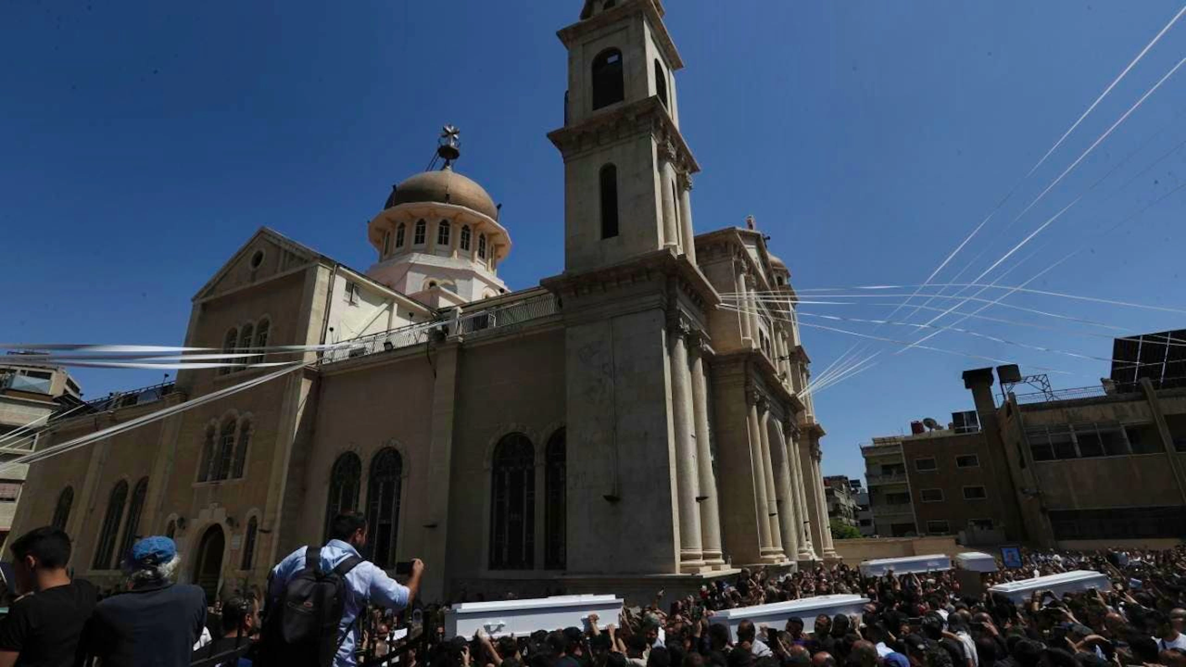Trauernde tragen Särge der Opfer des Selbstmordanschlag vom Sonntag, 22. Juni 2025, während einer Trauerfeier vor der griechisch-orthodoxen Mar-Elias-Kirche im Stadtteil Al-Duwaila. Foto: Omar Sanadiki/AP/dpa