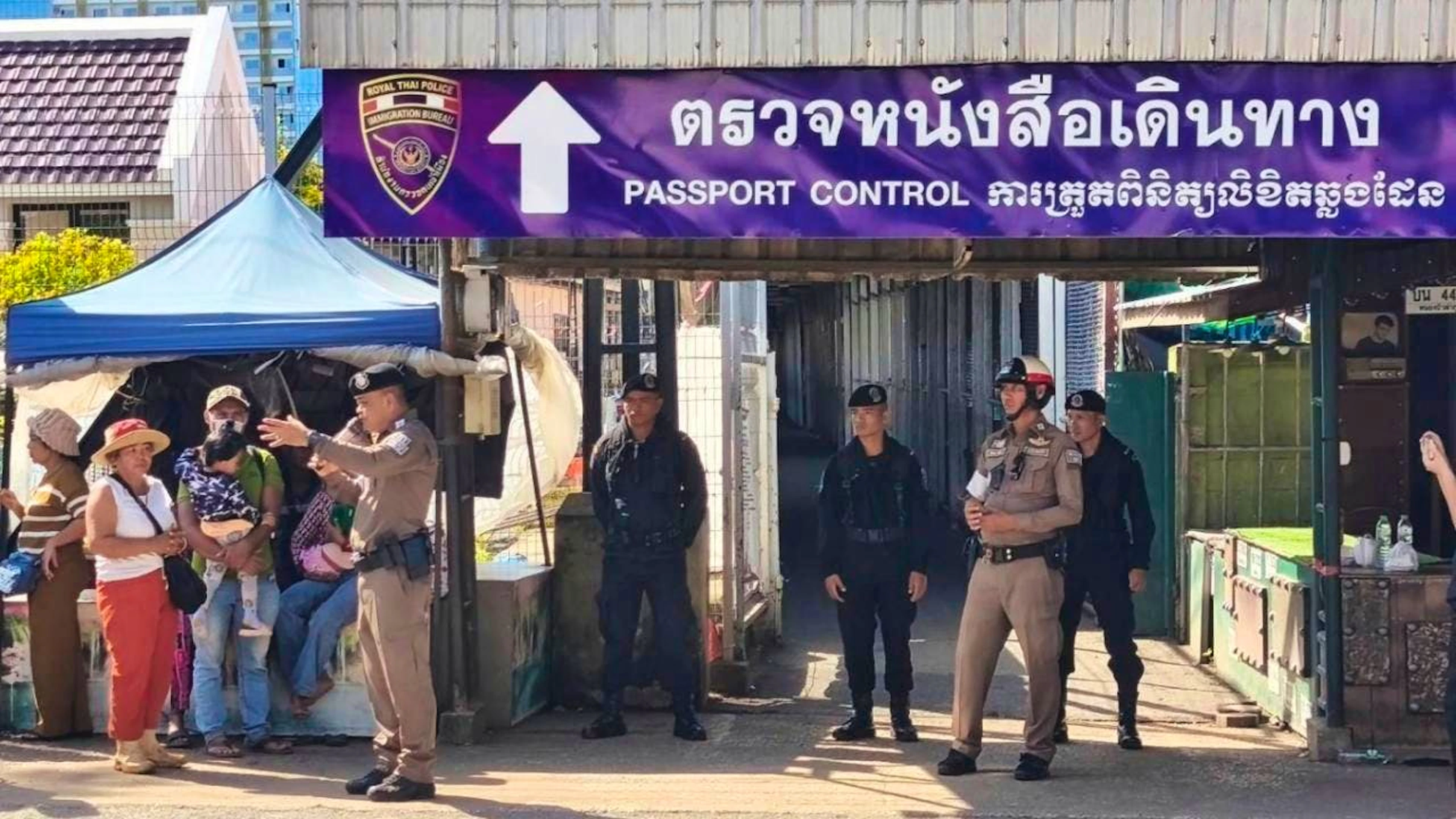 HANDOUT - Auf diesem von der Königlich Thailändischen Armee veröffentlichten Foto spricht ein thailändischer Polizist in der Provinz Sa Kaeo mit Menschen an einem Grenzübergang zwischen Thailand und Kambodscha. Foto: Uncredited/Royal Thai Army/AP/dpa - ACHTUNG: Nur zur redaktionellen Verwendung und nur mit vollständiger Nennung des vorstehenden Credits