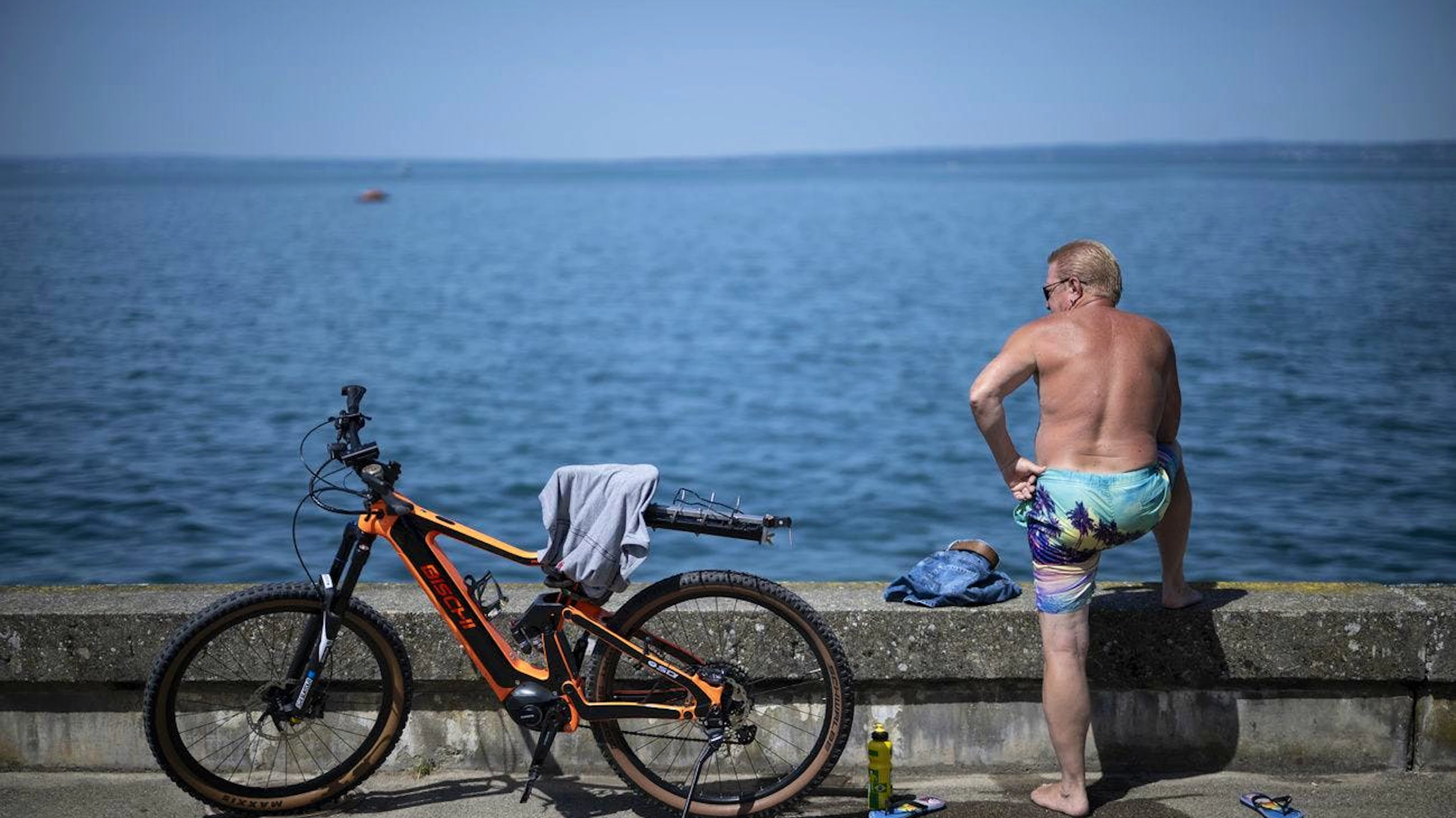 Ein Mann geniesst bei warmen Temperaturen am Bodensee die Sonne. Wer in der Nähe eines Sees wohnt, kann sich an heissen Tagen glücklich schätzen.