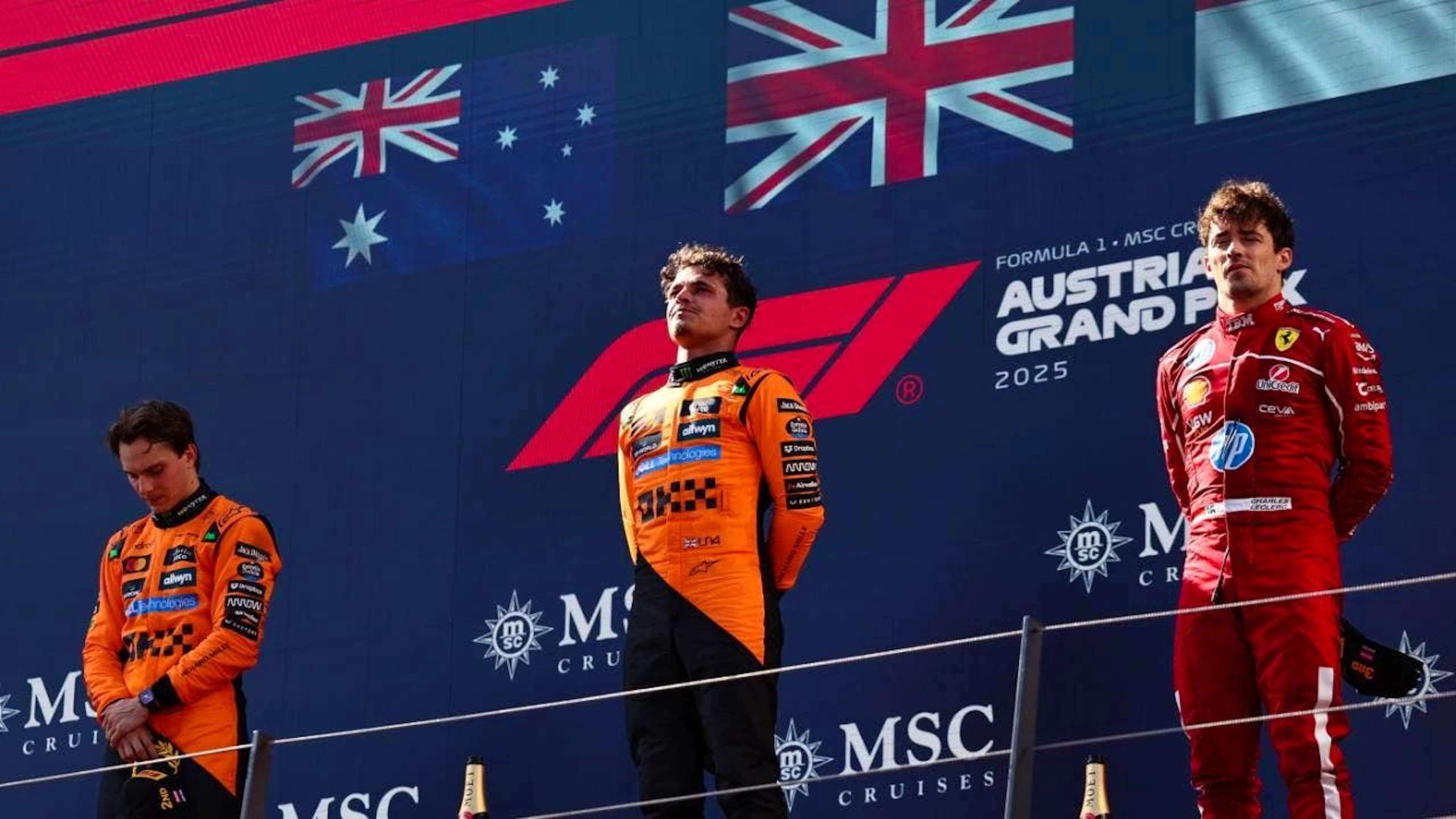 Strammstehen auf dem Podium (v.l.): Oscar Piastri, Lando Norris, Charles Leclerc