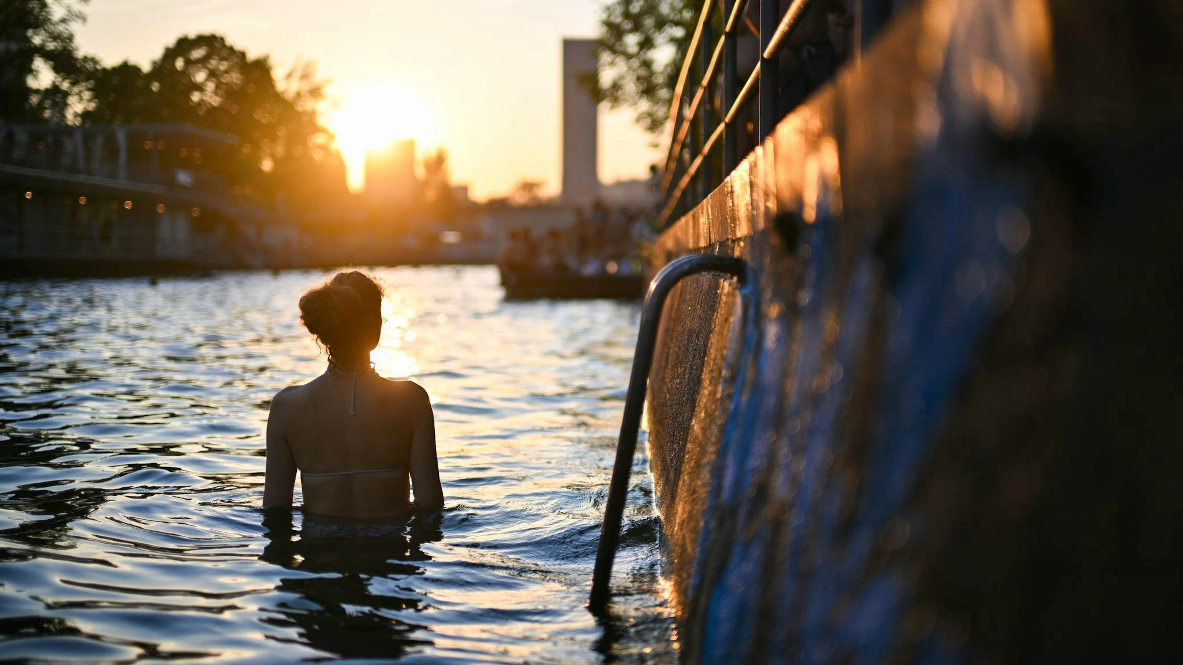 Tanja steht im Fluss Limmat in Zürich und geniesst die Erfrischung.