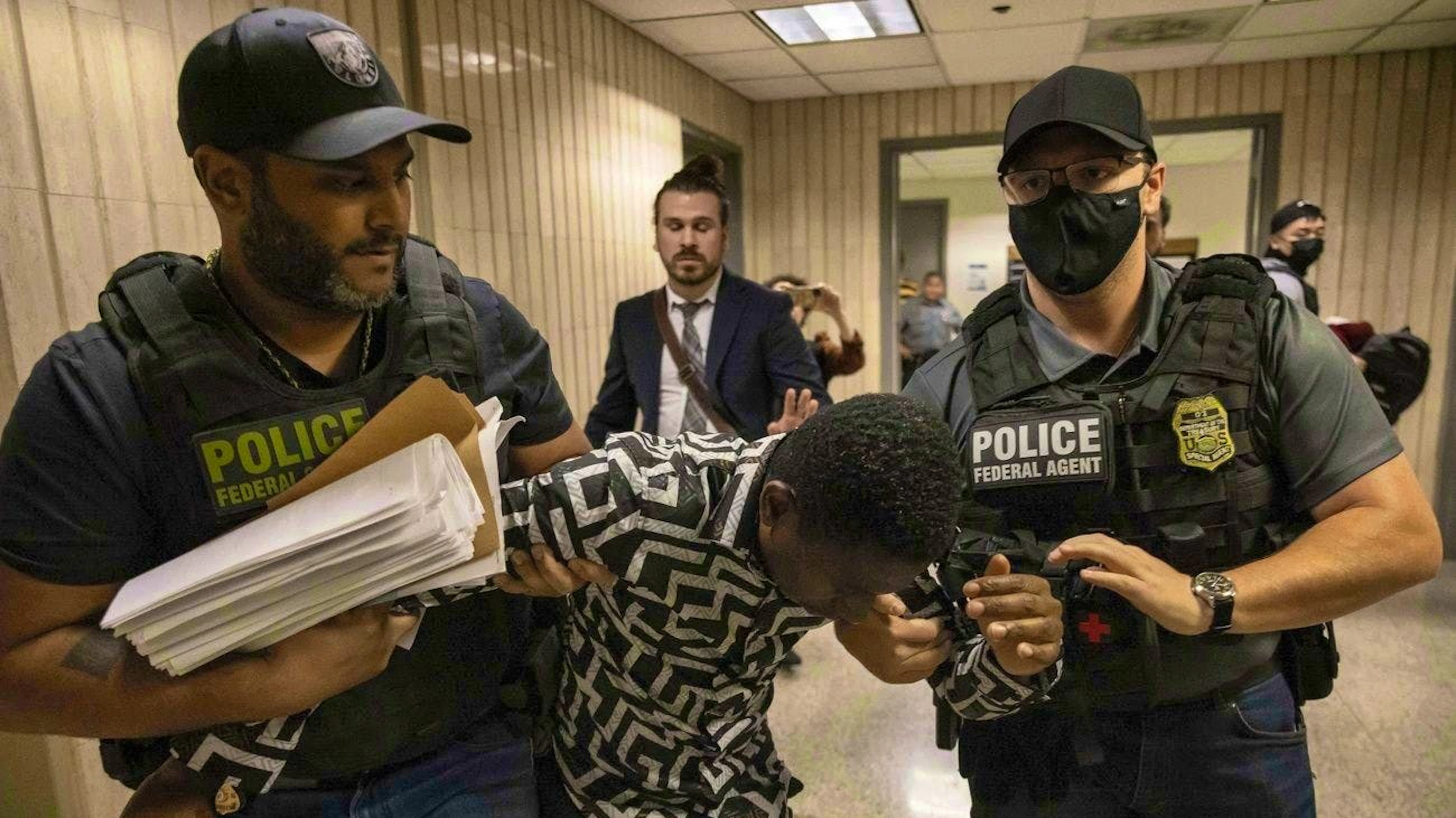 ICE agents arrest a person outside an immigration courtroom in New York on June 10.