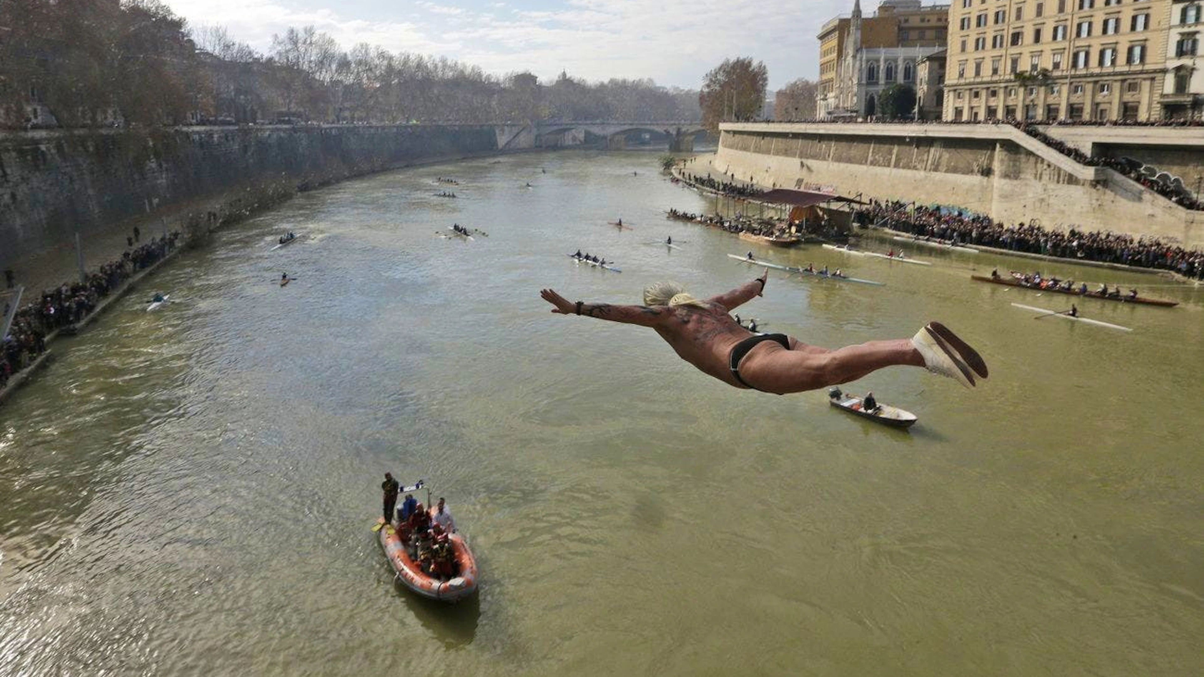Beim traditionellen Brückenspringen in Rom stürzen sich jedes Jahr mutige Menschen in den Tiber. Das Schwimmen in dem schmutzigen Fluss ist jedoch verboten.