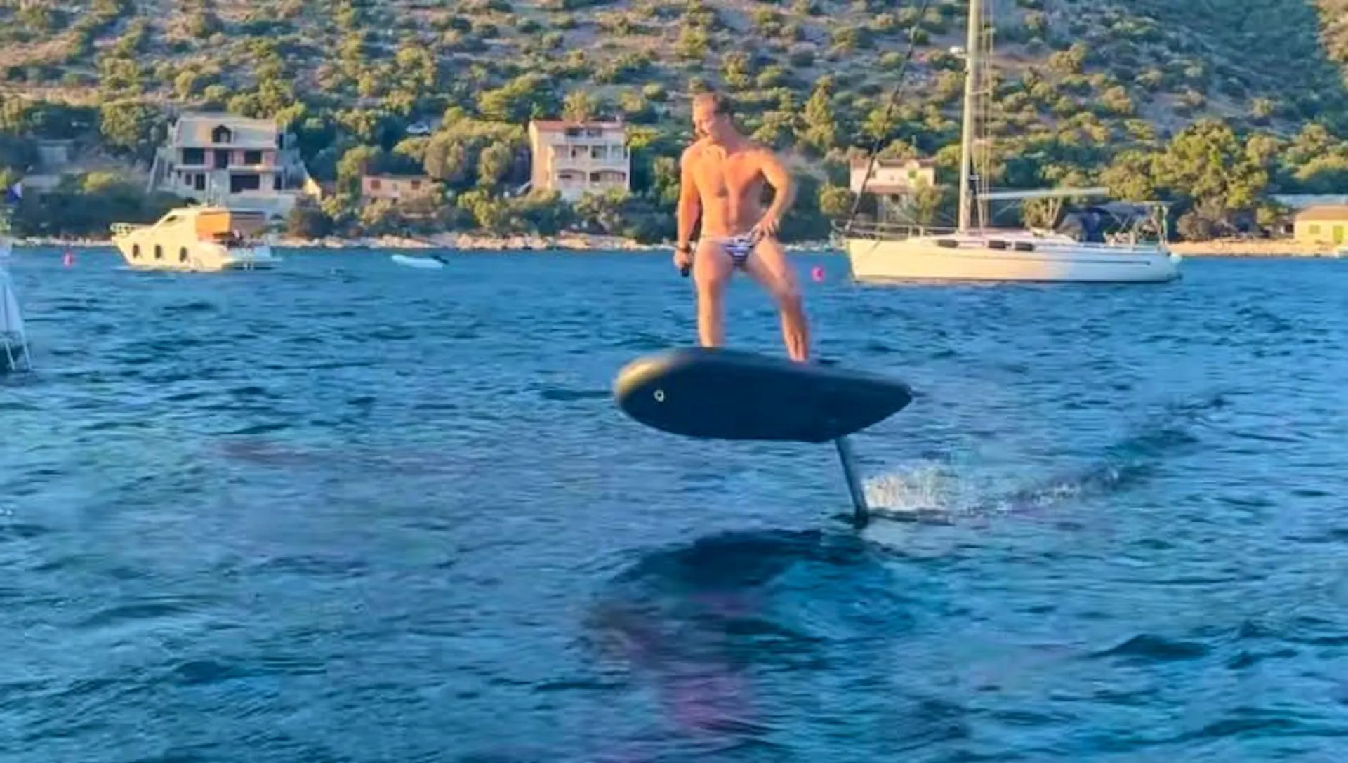 Marco Odermatt has fun in Speedos on an electric surfboard