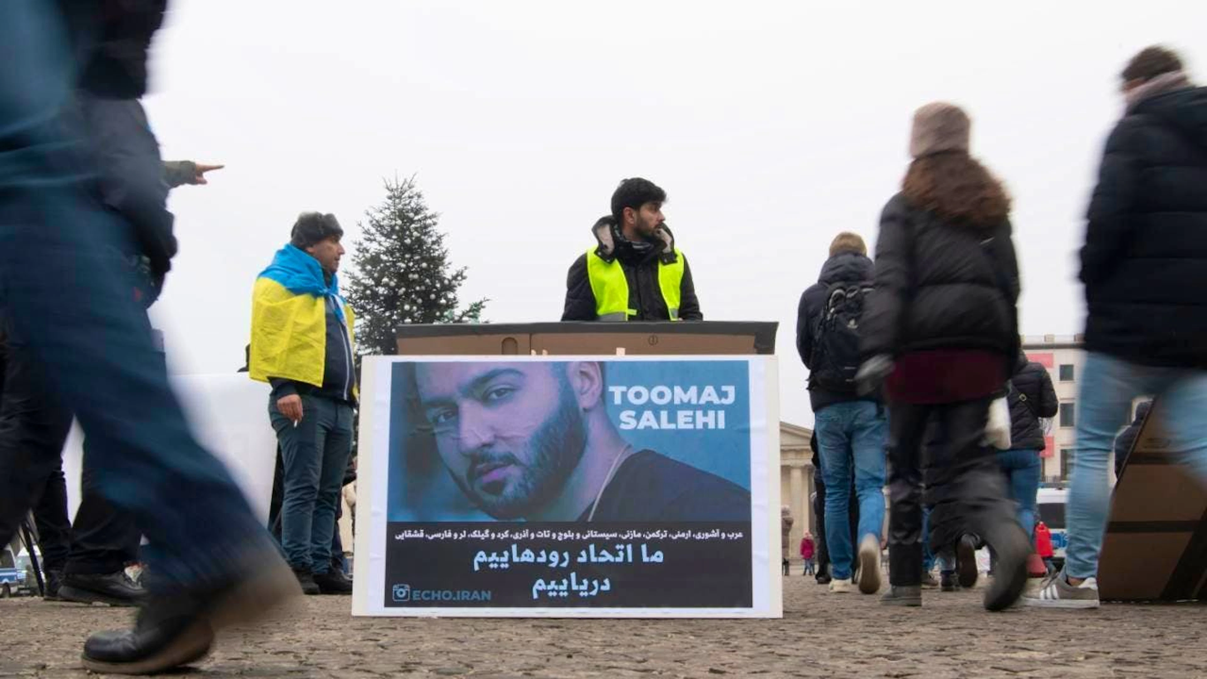 ARCHIV - Ein großes Plakat steht bei einer Protestaktion gegen Irans Regierung in Berlin. Es zeigt den iranischen Rapper Tumadsch Salehi. Foto: Paul Zinken/dpa