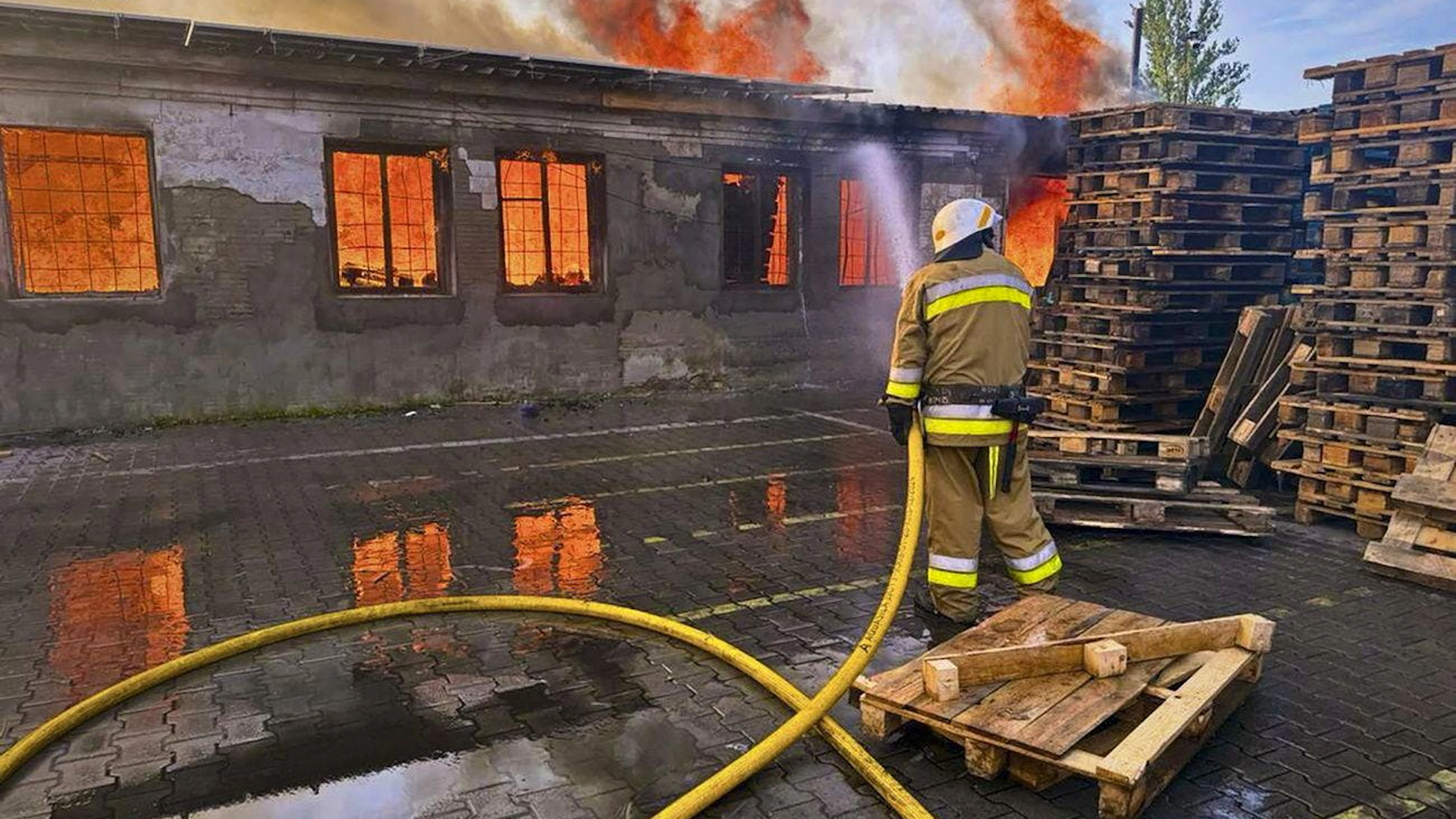 I servizi d'emergenza ucraini intenti a domare le fiamme, dopo l'attacco di un drone russo.