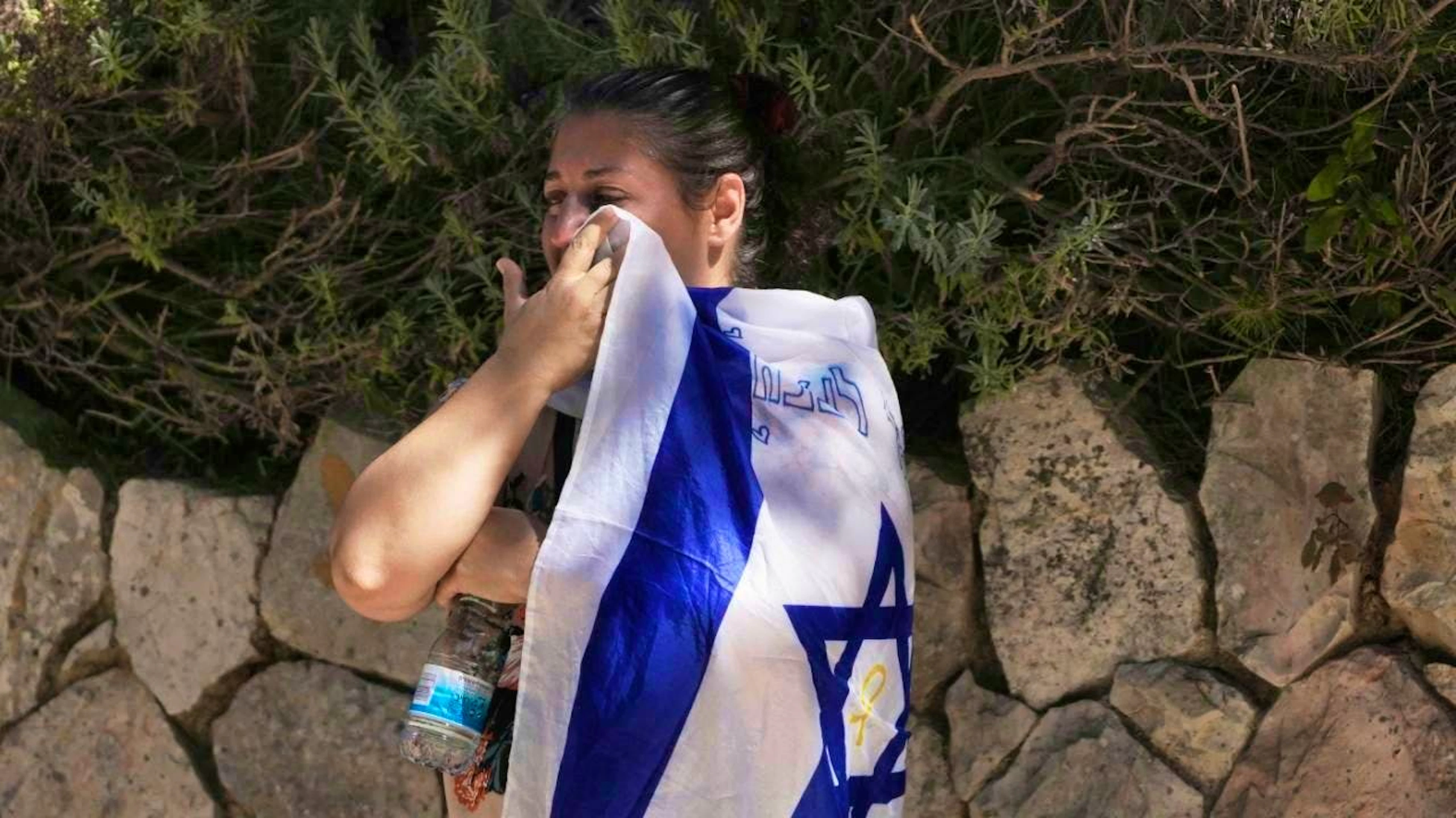 A mourner wipes her tears with the Israeli national flag at the funeral of Noam Aharon Musgadian, a staff sergeant in the Israel Defense Forces who was killed in the Gaza Strip, at the Mount Herzl military cemetery in Jerusalem. Photo: Maya Alleruzzo/AP/dpa