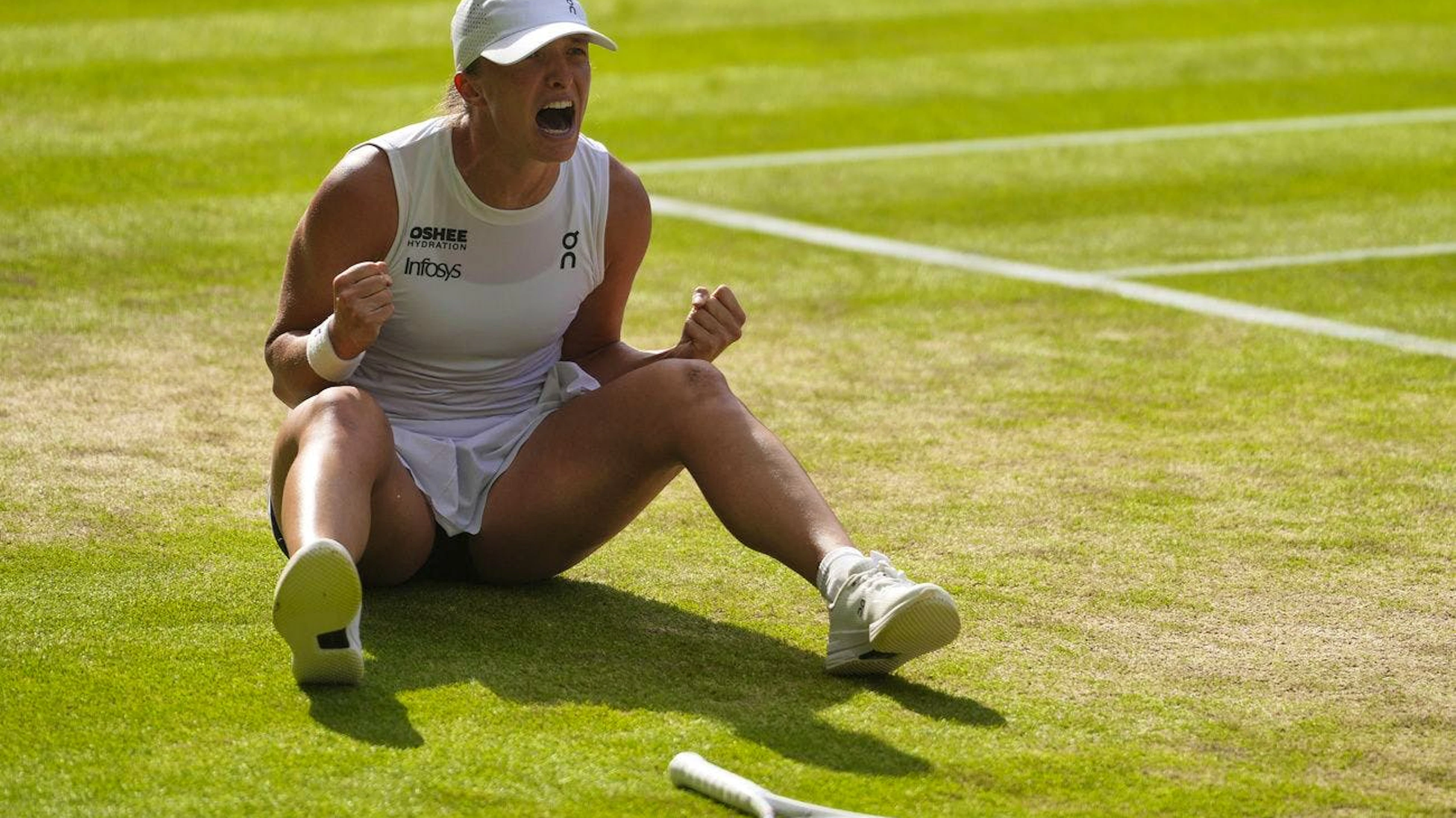 Iga Swiatek celebra la prima vittoria assoluta sul prato di Wimbledon.