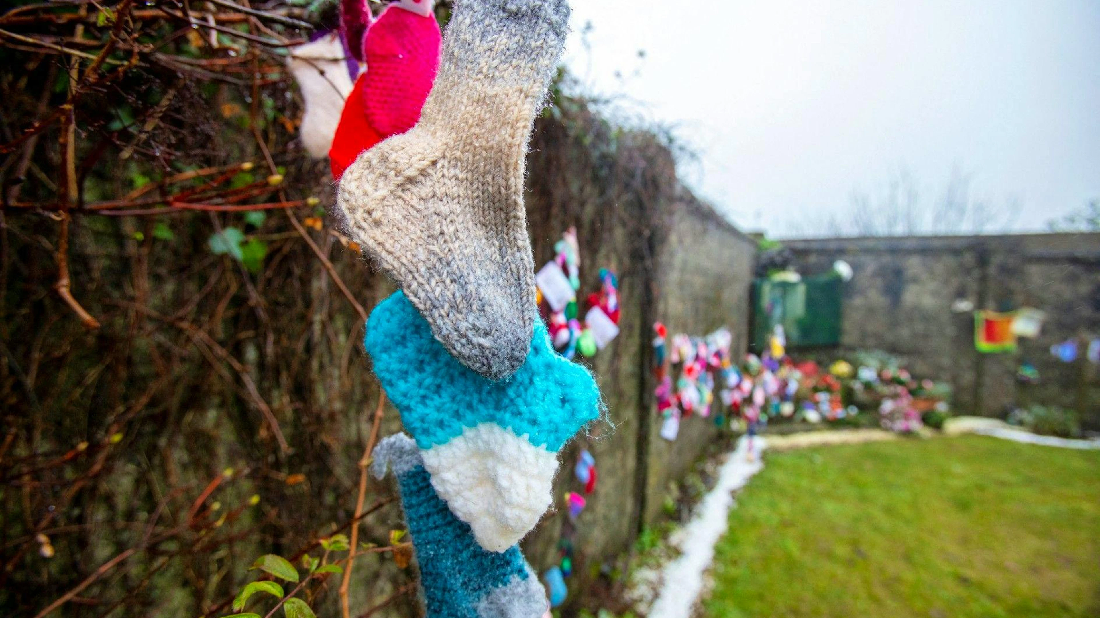 Baby socks and hearts are pictured at a shrine in Tuam, County Galway in January 13, 2021, erected in memory of up to 800 children who were allegedly buried at the site of the former home for unmarried mothers run by nuns. Irish prime minister Micheal Martin on Wednesday formally apologised for the treatment of unmarried women and their babies in state and church-run homes, where thousands of children died over decades. Some 9,000 children died in Ireland's "mother and baby homes", where unmarried mothers were routinely separated from their infant offspring, according to an official report published Tuesday. (Photo by Paul Faith / AFP)