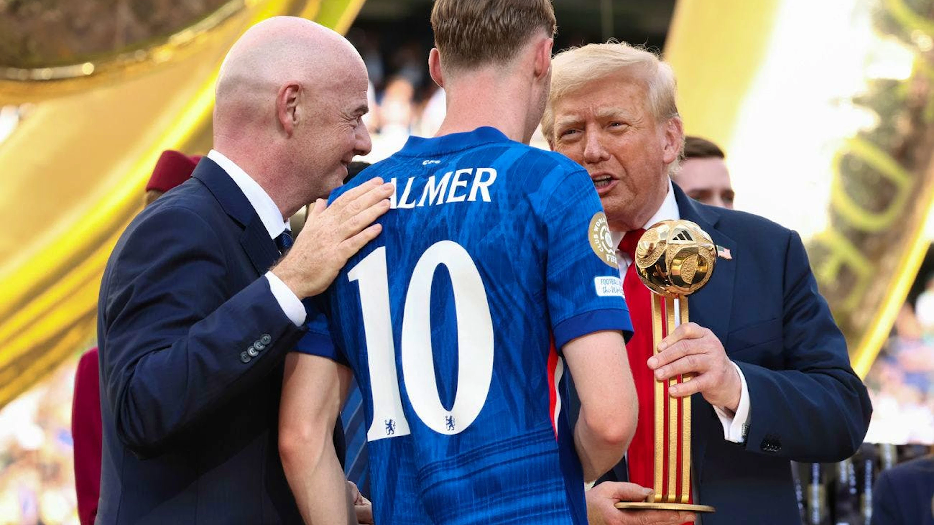 Il presidente Donald Trump, a destra, e il presidente della FIFA Gianni Infantino, a sinistra, consegnano a Cole Palmer del Chelsea il trofeo del pallone d'oro dopo la vittoria del Chelsea contro il Paris St Germain nella finale della Coppa del Mondo per club, al MetLife Stadium di East Rutherford, nel New Jersey.