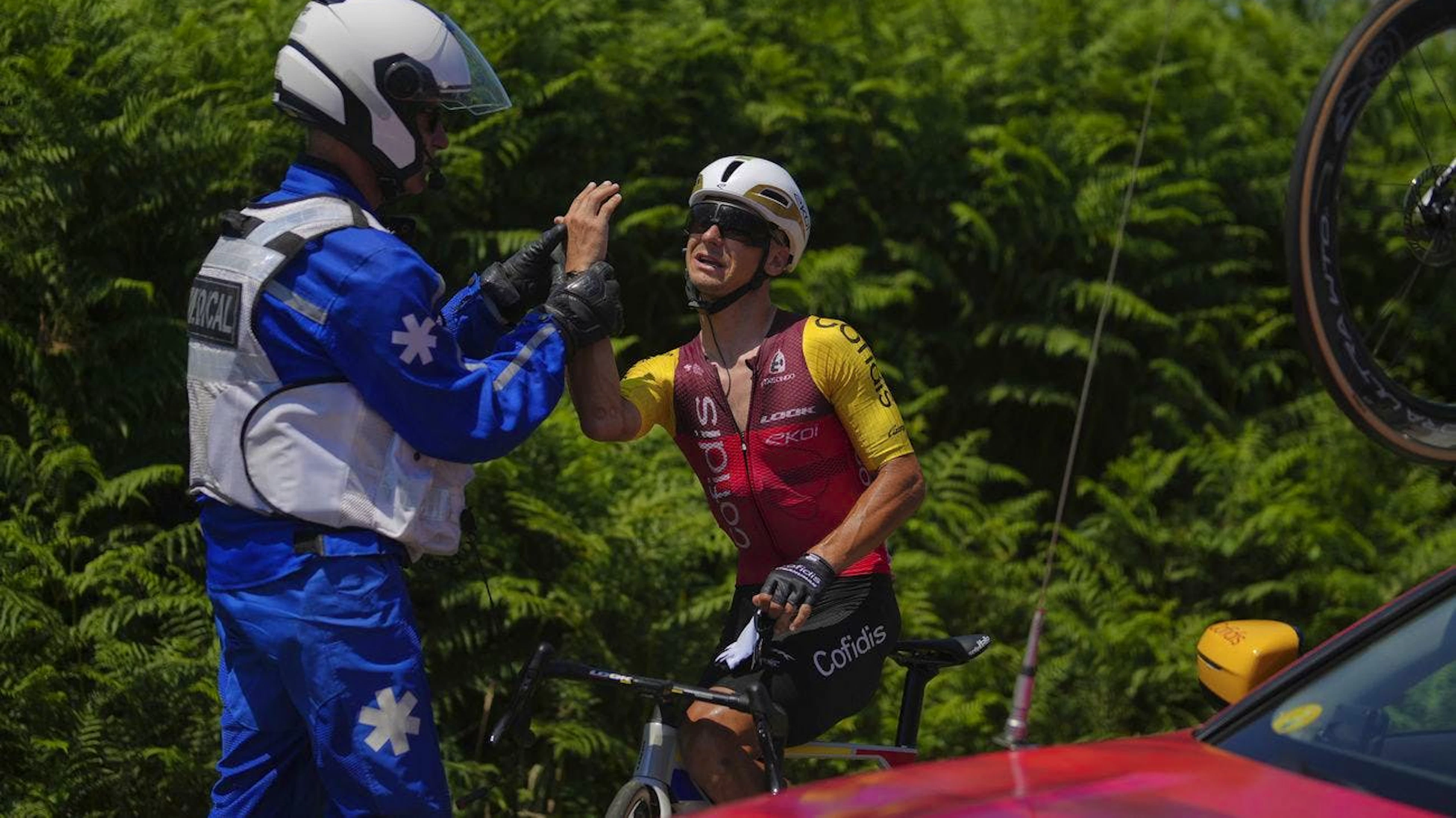 Le Français Bryan Coquard reçoit des soins médicaux après s'être blessé à la main droite dans la zone de ravitaillement.