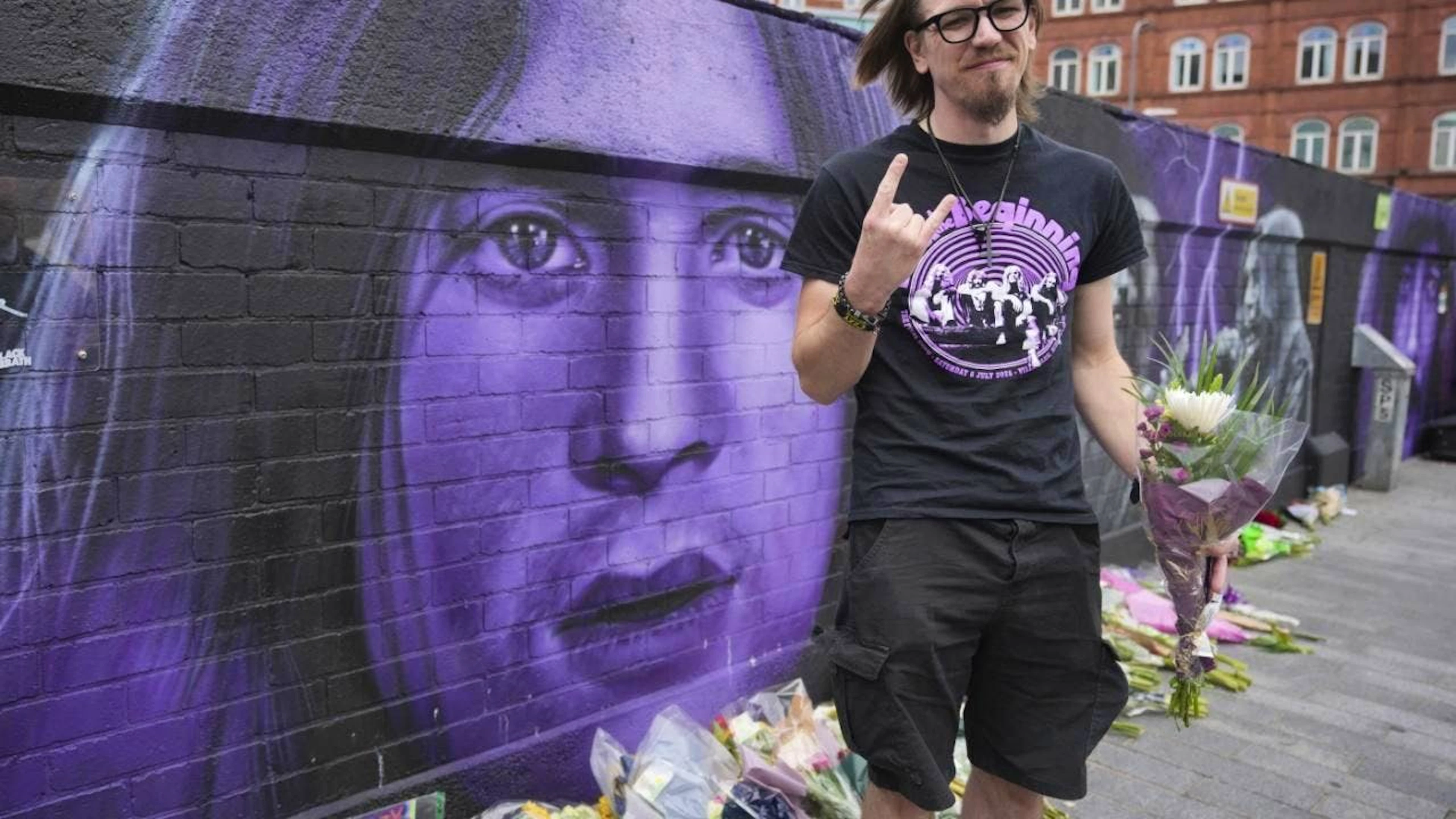 Matthew Caldwell, fan de musique, tient des fleurs en hommage à Ozzy Osbourne, décédé à Birmingham mardi.