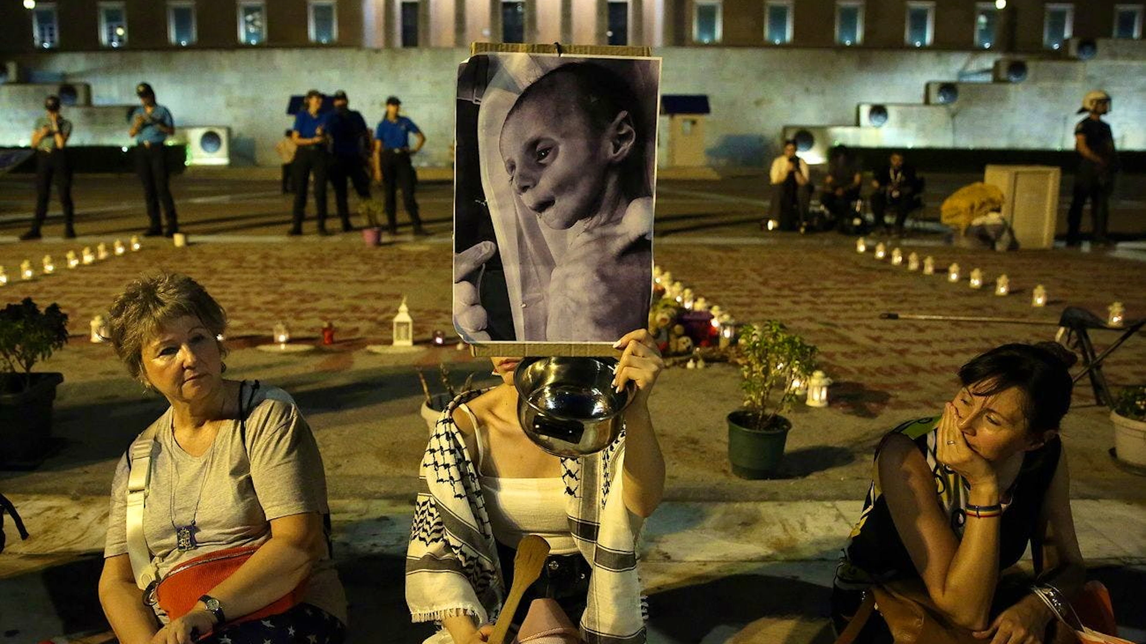 Des manifestants brandissent des photos d’enfants affamés de Gaza lors d’un rassemblement pro-palestinien à Athènes, en Grèce, le 24 juillet 2025.