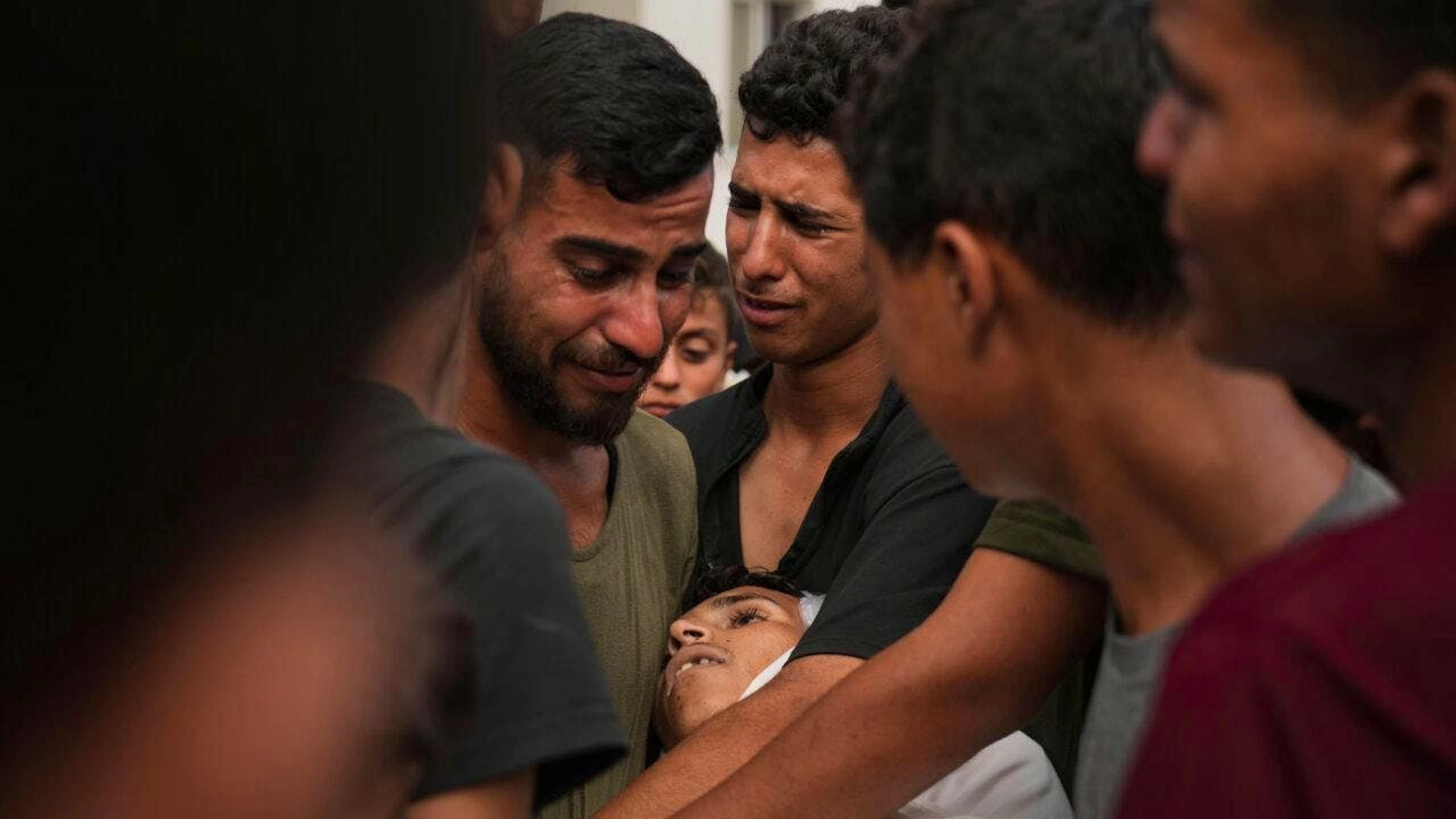 Des Palestiniens à l'hôpital Al-Chifa, près du corps d'un proche tué alors qu'il tentait d'approcher les camions d'aide.