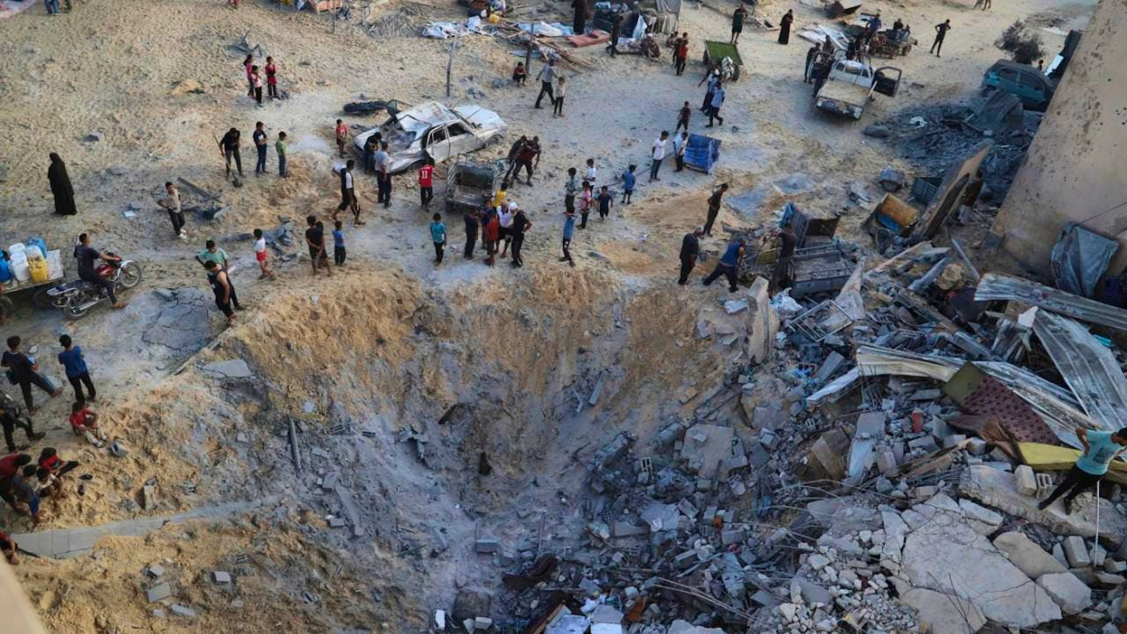 Palästinenser inspizieren die von einem israelischen Bombardement betroffene Stelle in Muwasi, Khan Younis, Gazastreifen. Foto: Mariam Dagga/AP/dpa