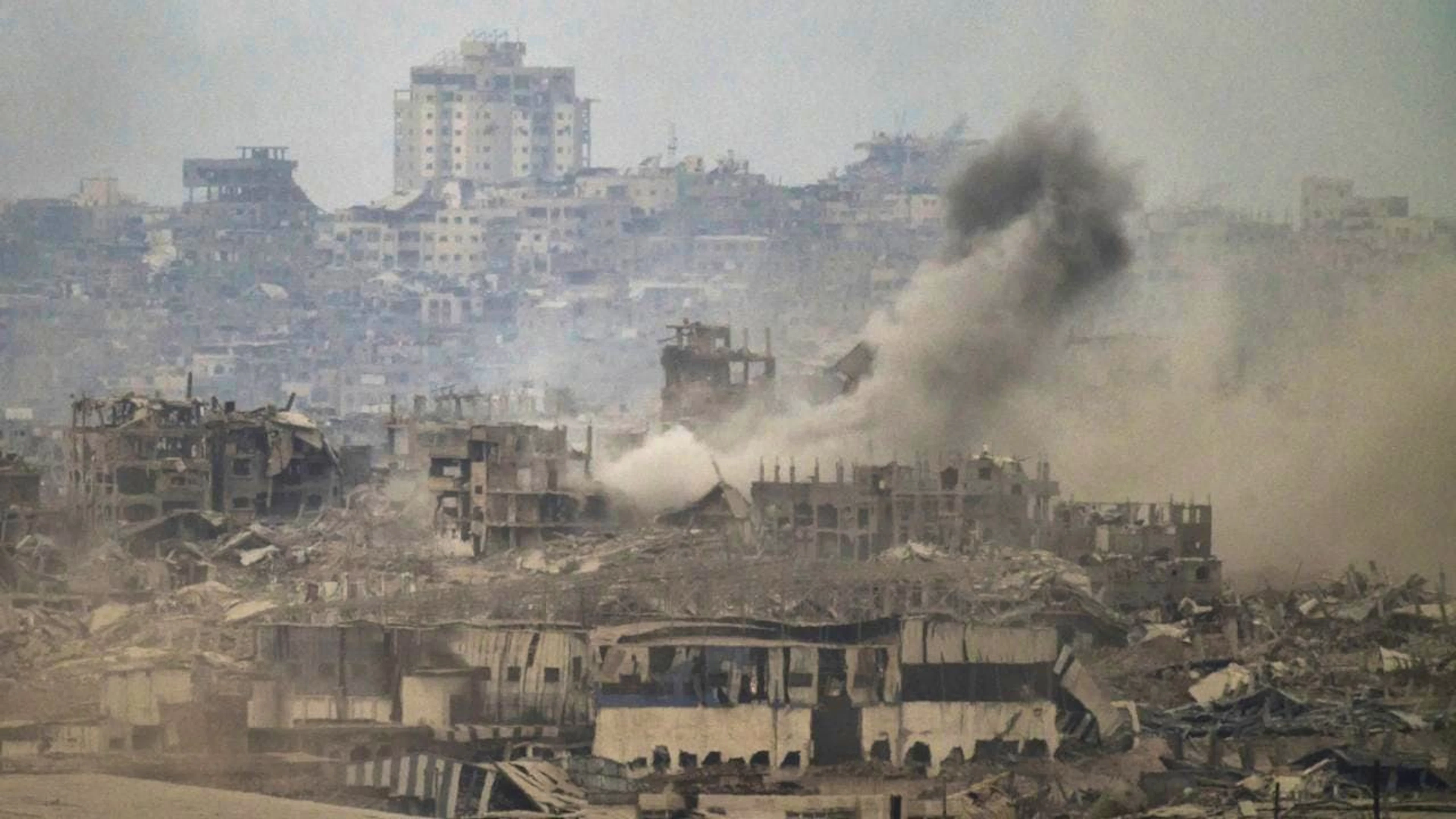 Rauch steigt inmitten zerstörter Gebäude nach einem israelischen Beschuss im Gazastreifen auf, gesehen vom Süden Israels aus. Foto: Leo Correa/AP/dpa